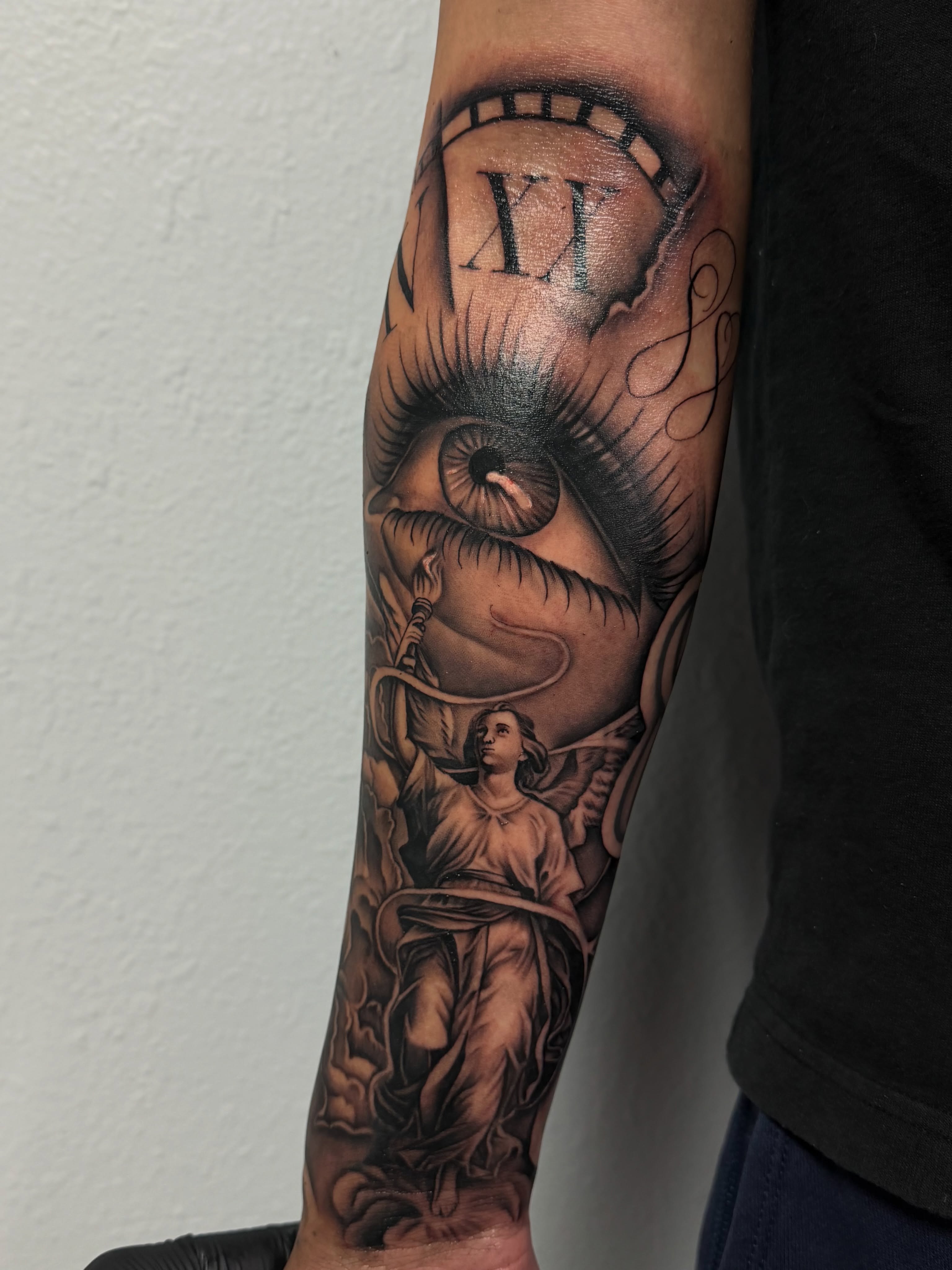 Eye and angel realism tattoo on the forearm by San Diego Tattoo Artist