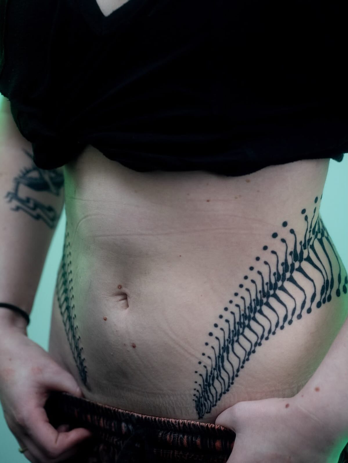 Dots and lines dotwork tattoo on the torso by Josaline Green