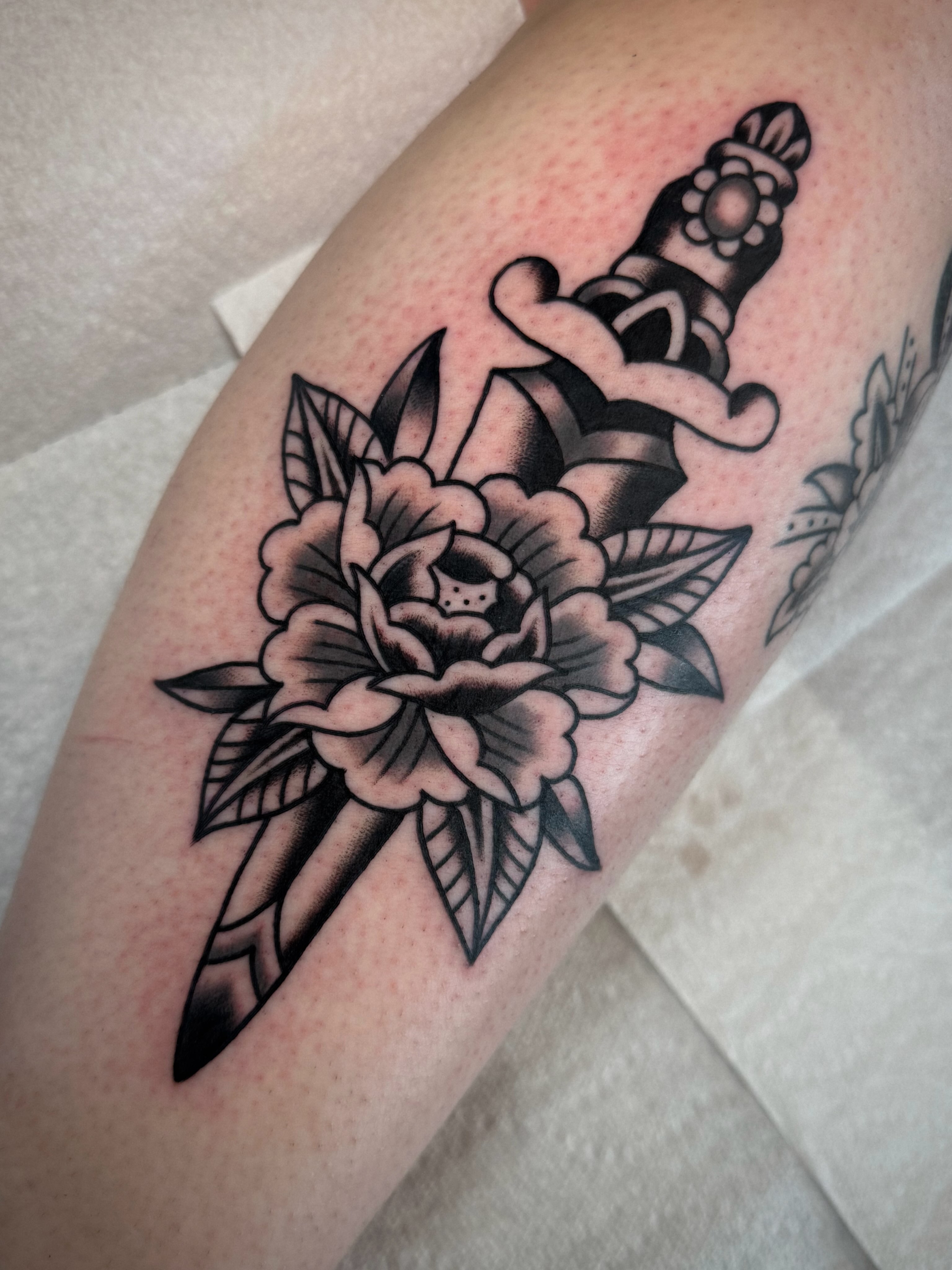 Flower and dagger American traditional tattoo on the forearm by Emily Devenz