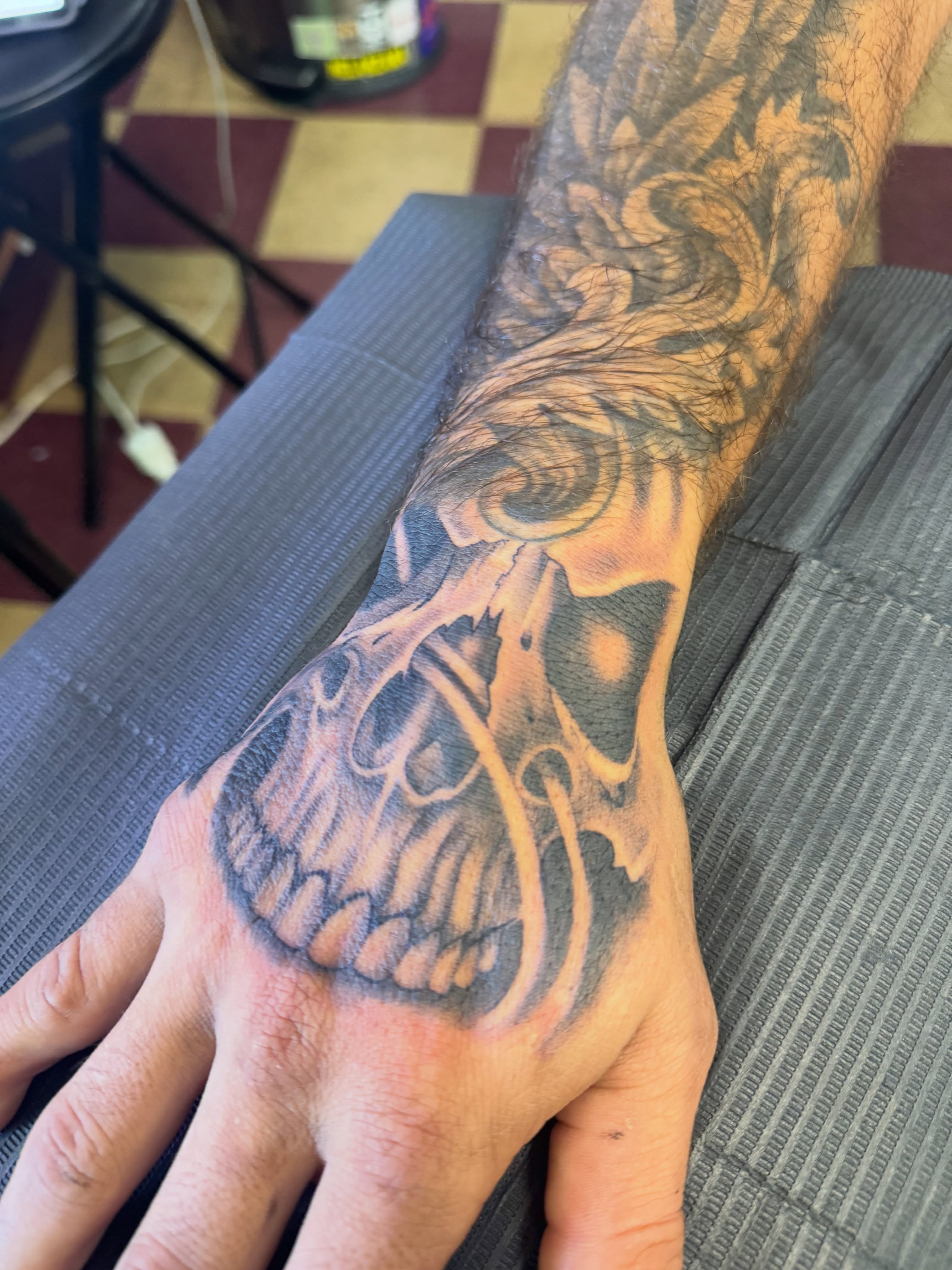 Skull black and grey tattoo on the hand by Cora Phelps