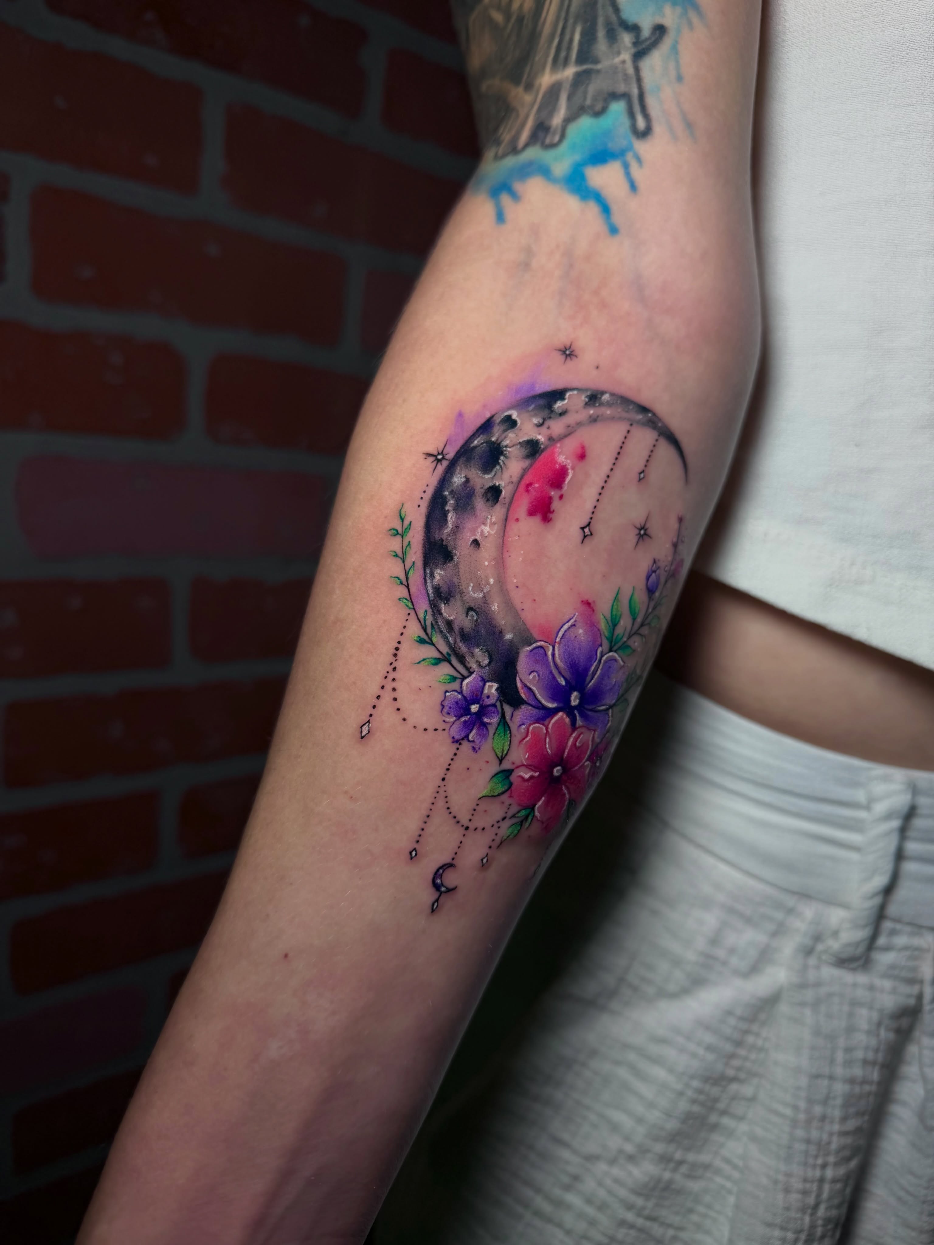 Moon and flowers watercolor tattoo on the forearm by Keyla Valdes, Miami, Florida