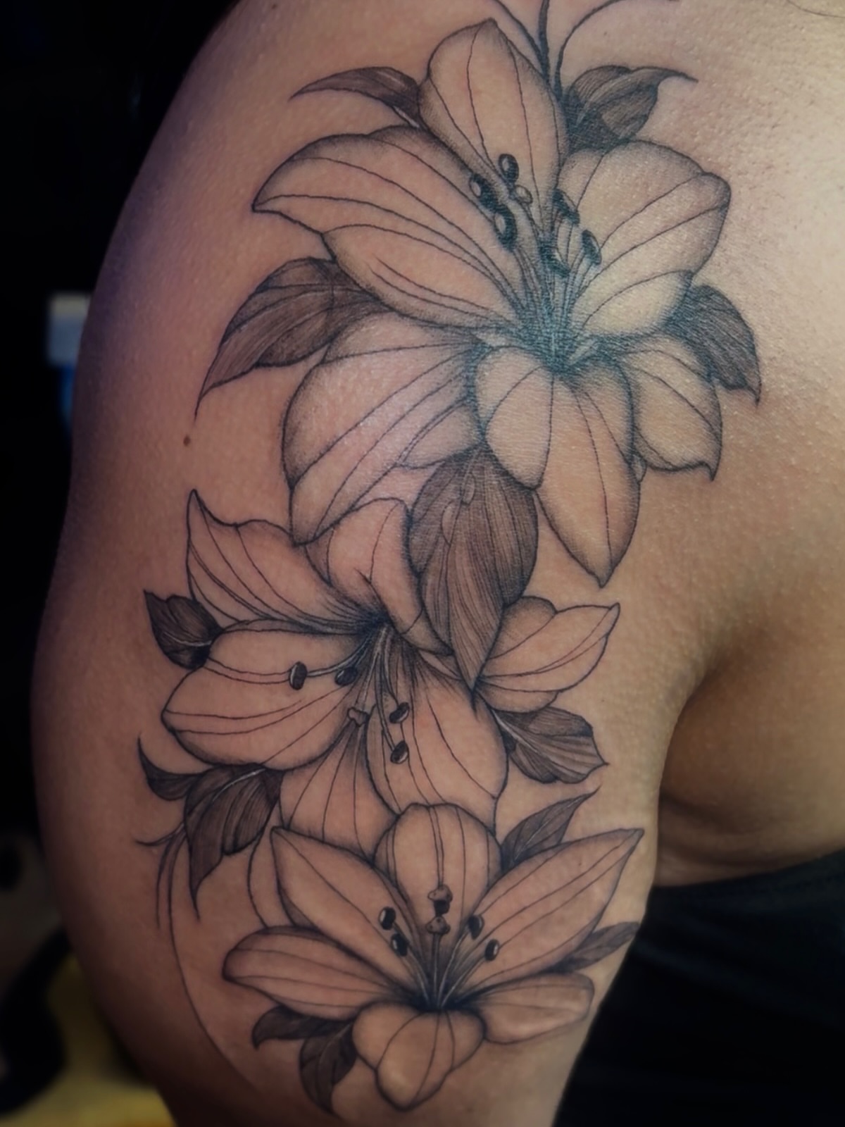 Lilies black and grey tattoo on the shoulder by 𝔾𝔥𝓸ş𝔱
