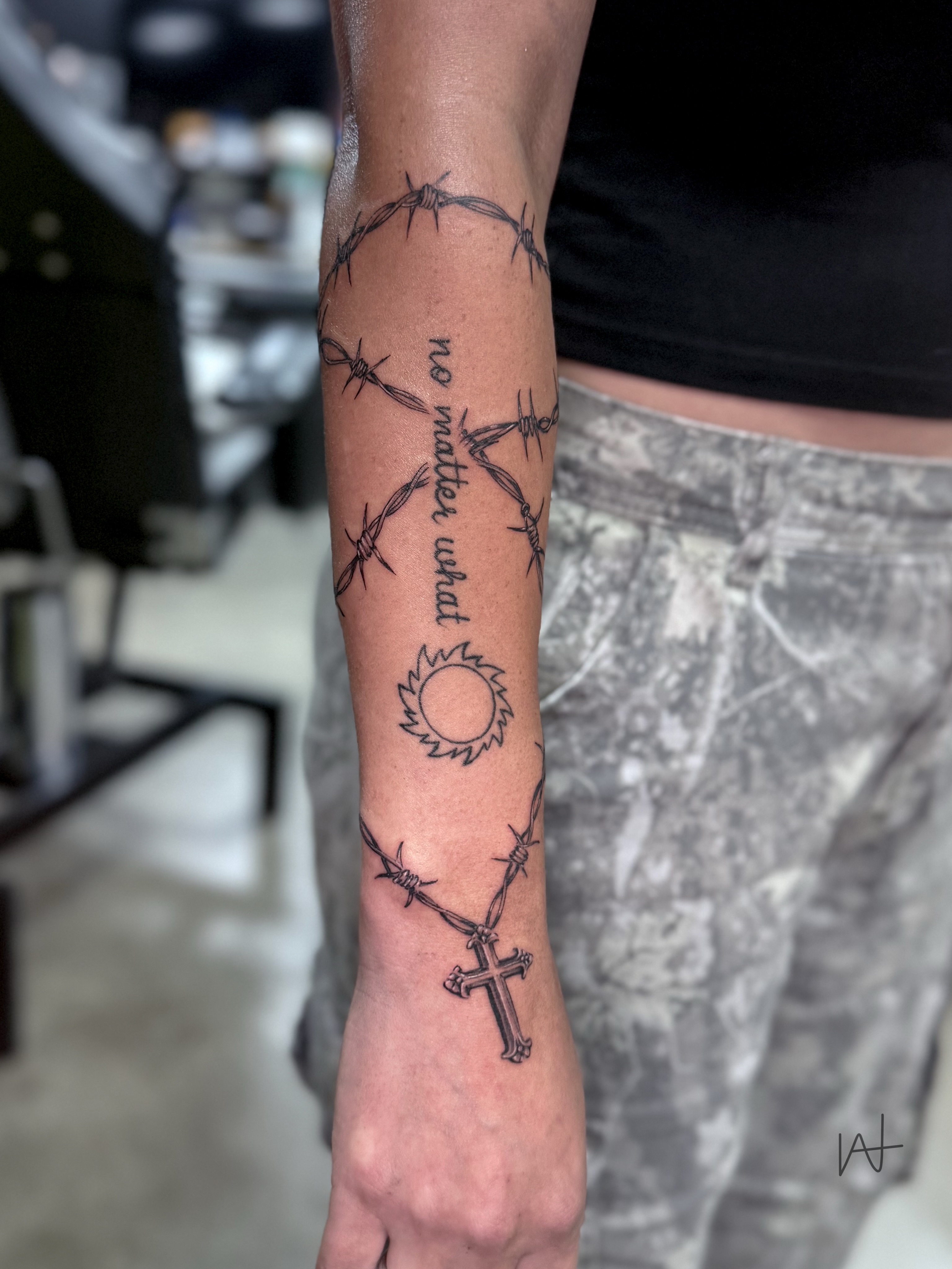 Barbed wire and cross black and grey tattoo on the forearm by Kat Parmu
