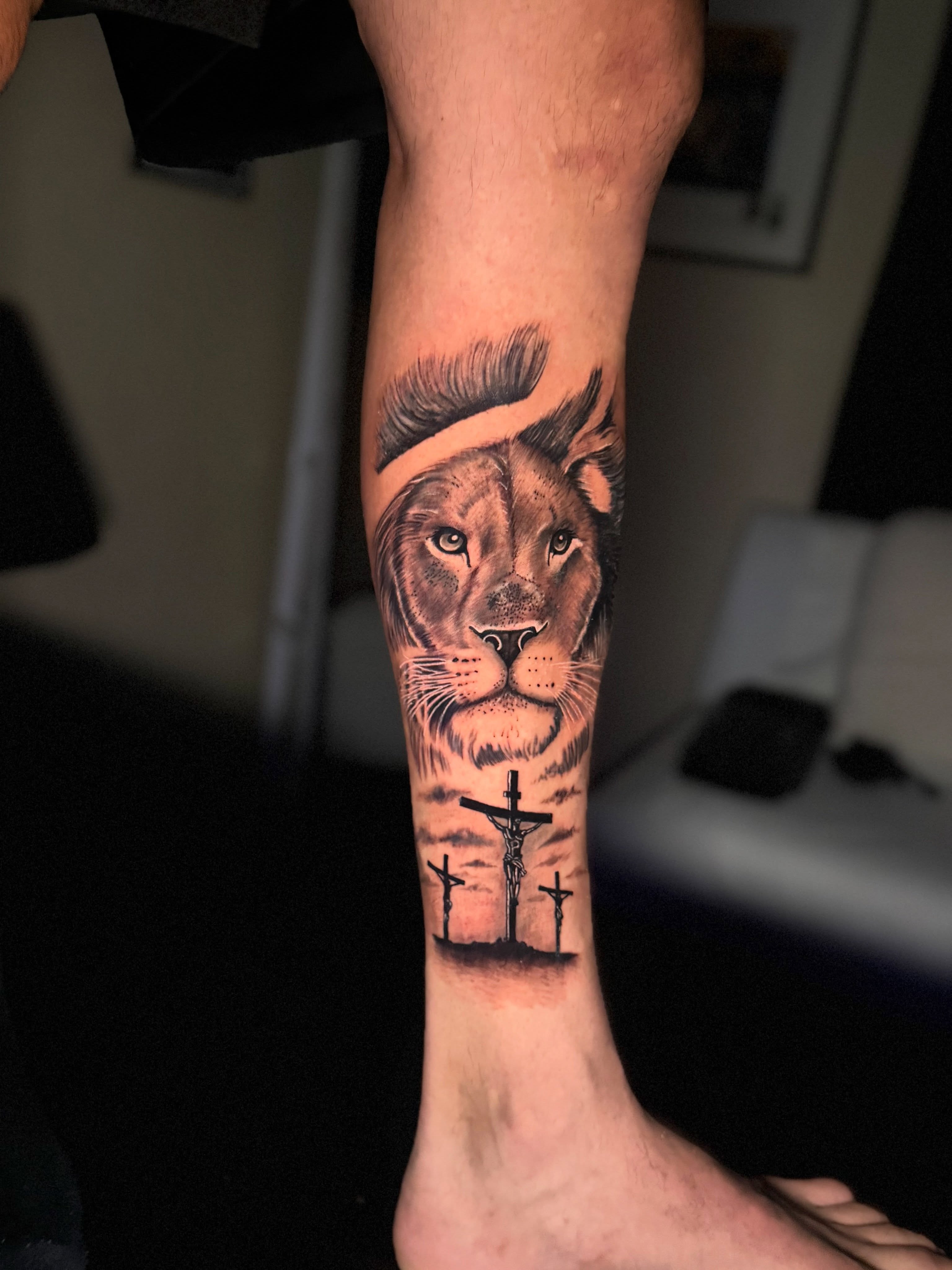Lion and crucifixion realism tattoo on the forearm by Aldocasales@tatto
