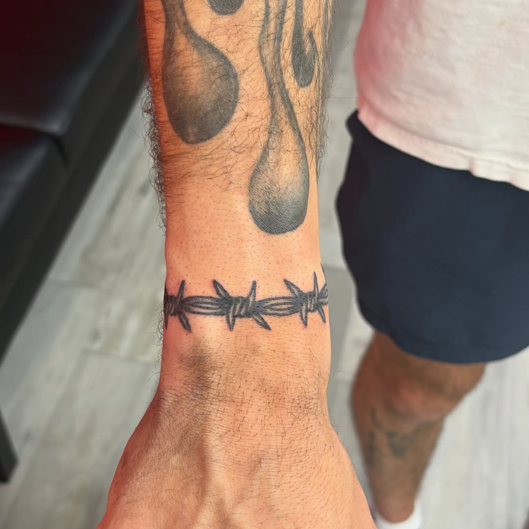 Barbed wire black and grey tattoo on the forearm by Landon Bagley