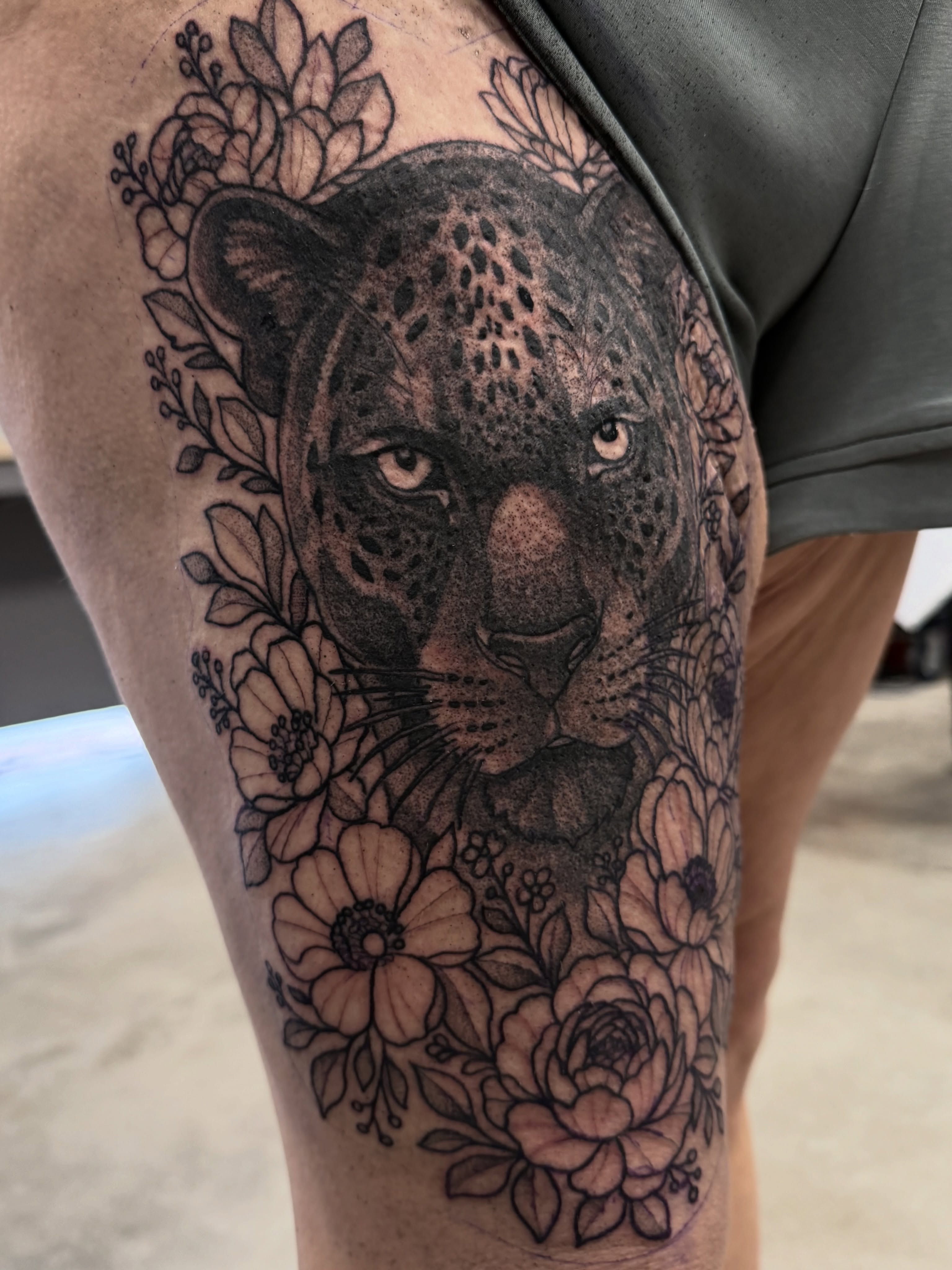Jaguar with floral crown dotwork tattoo on the thigh by Christopher Layman