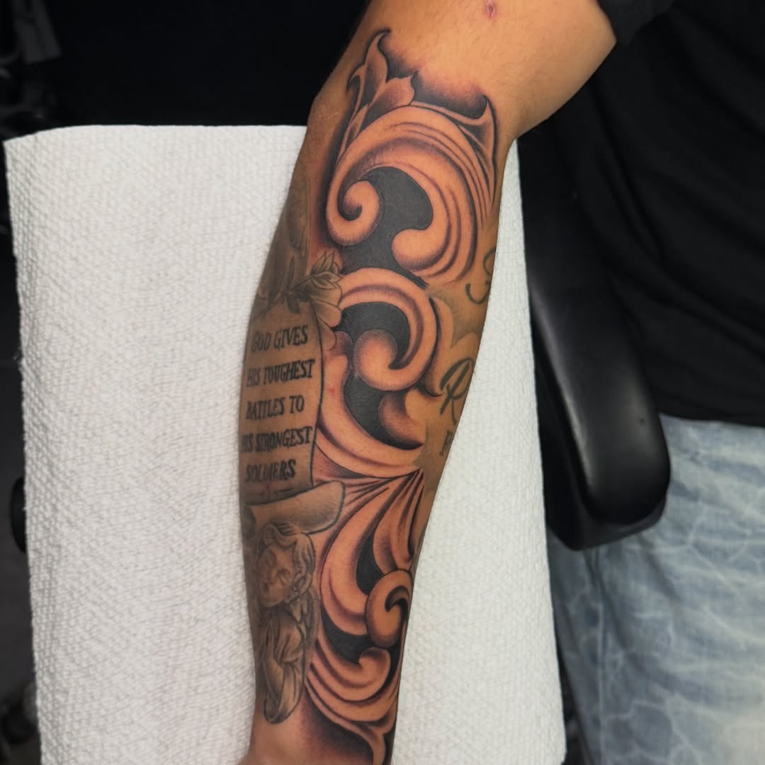 Scrollwork and angel ornamental tattoo on the forearm by Kimberly landin