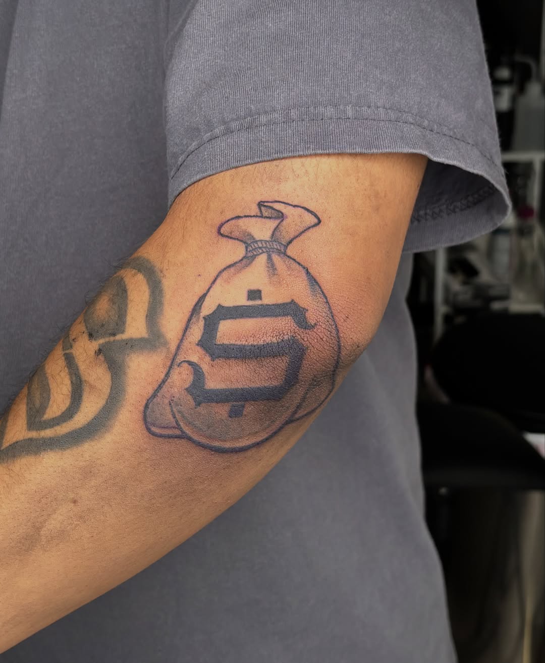 Money bag black and grey tattoo on the forearm by Las Vegas Tattoo Artist ๐ฒโ๏ธ