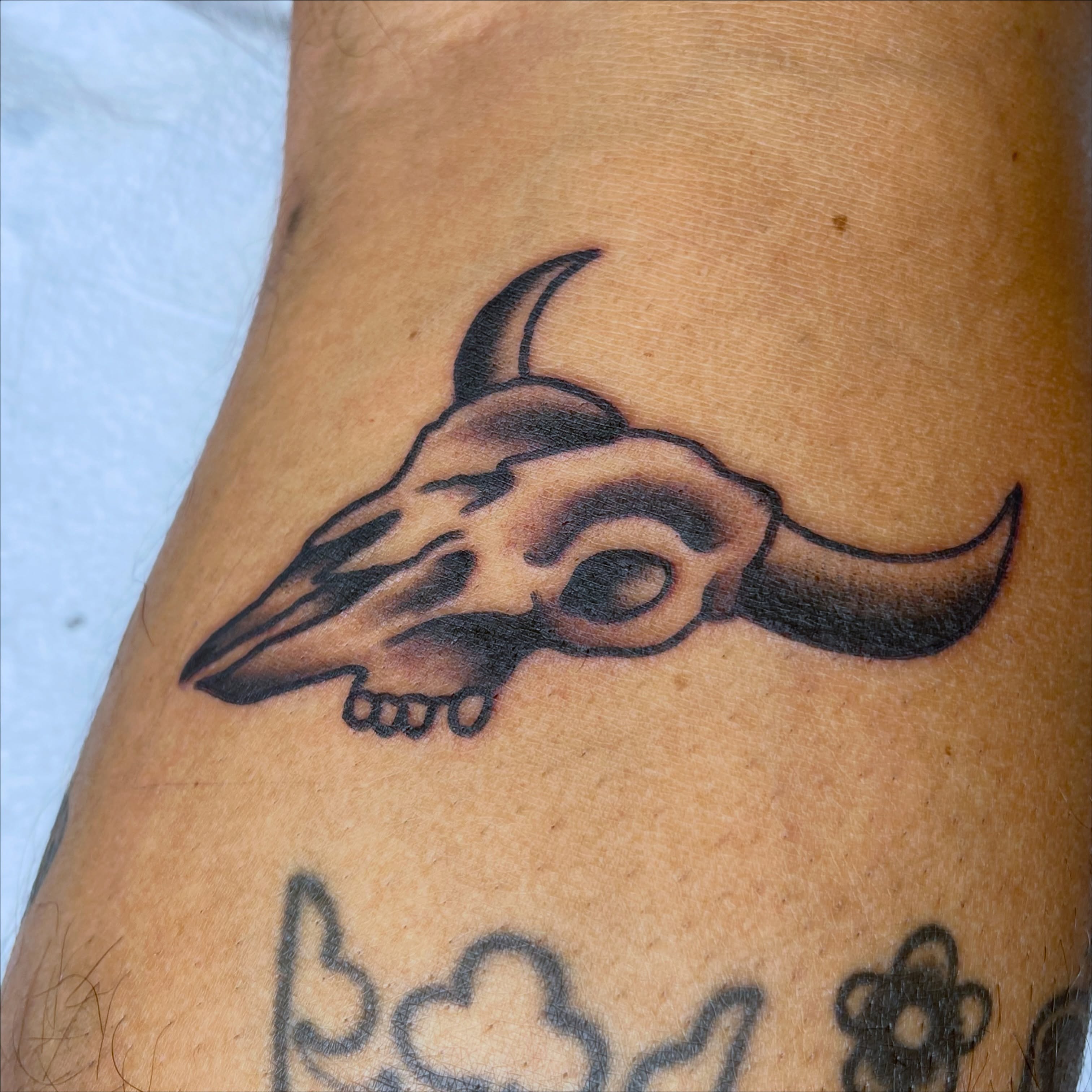 Bull skull black and grey tattoo on the forearm by Chris Martin