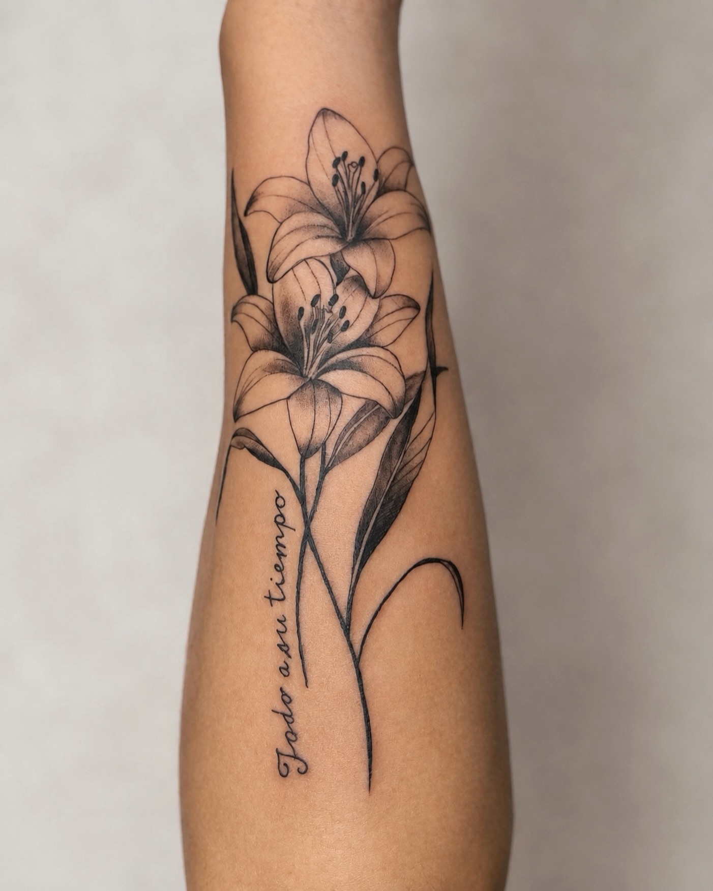 Lily black and grey tattoo on the forearm by Kate