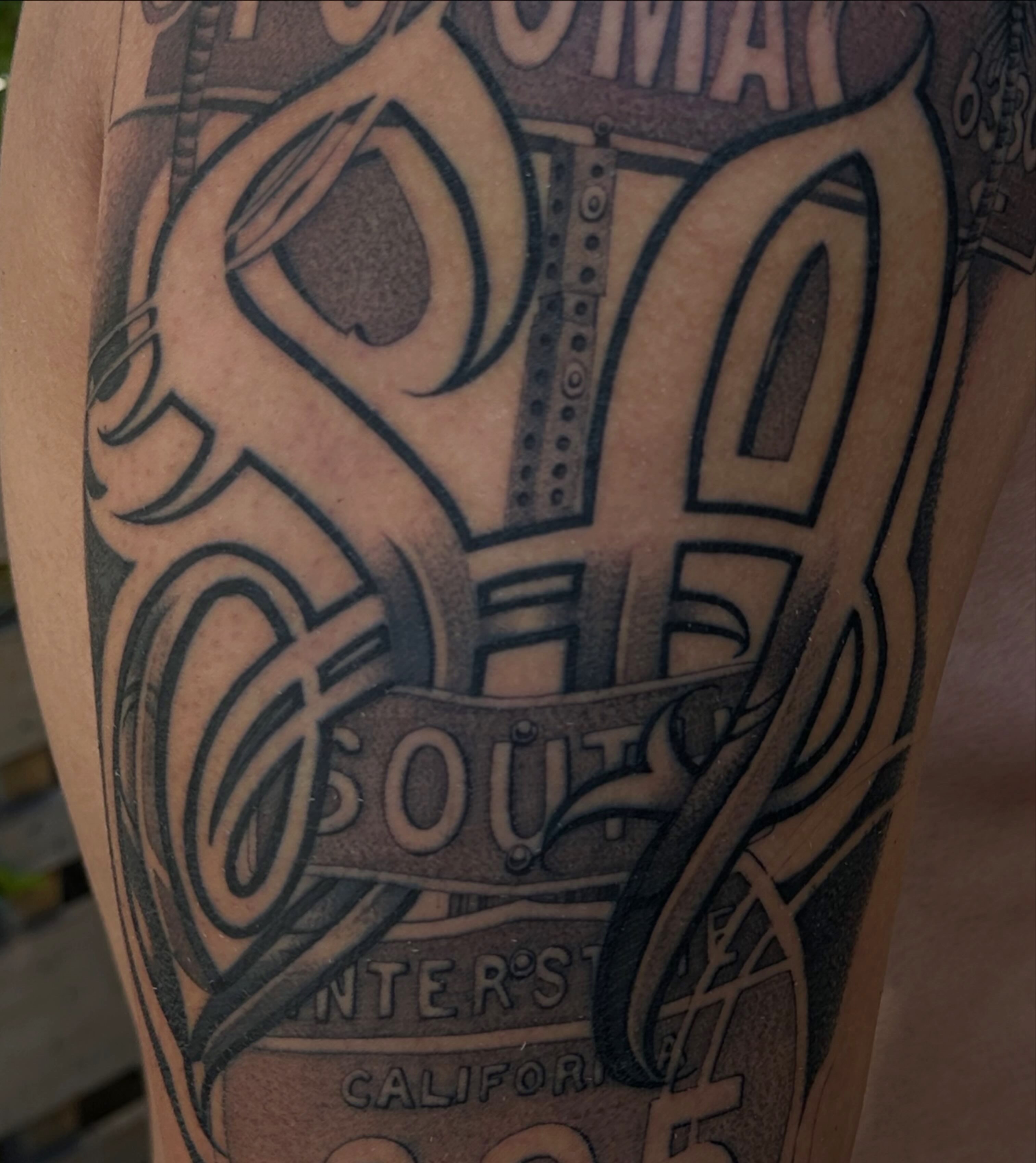 Road sign black and grey tattoo on the forearm by San Diego Tattoo Artist