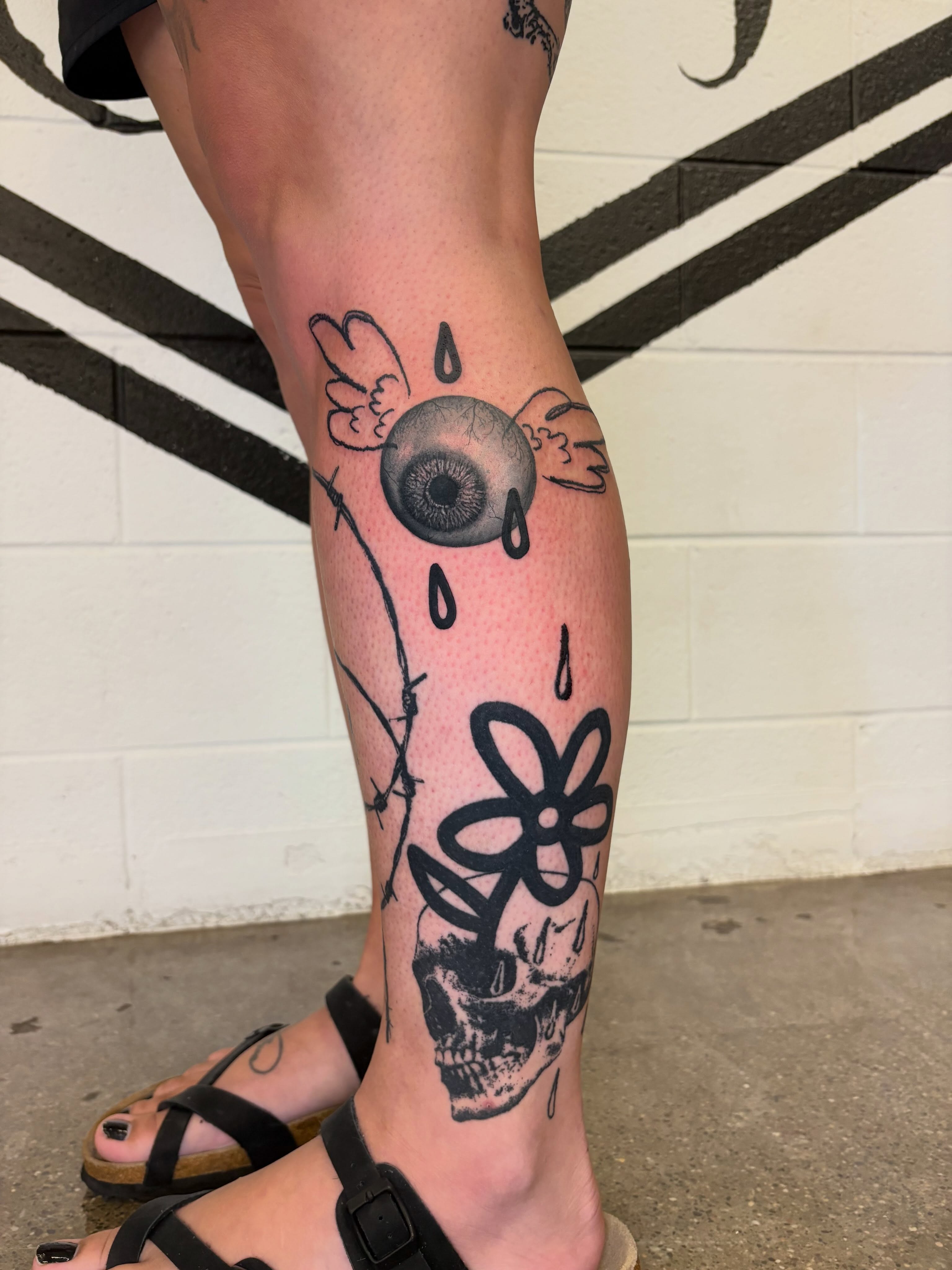 Eye and flower black and grey tattoo on the calf by @lil_stinker_5000, Portland, Oregon