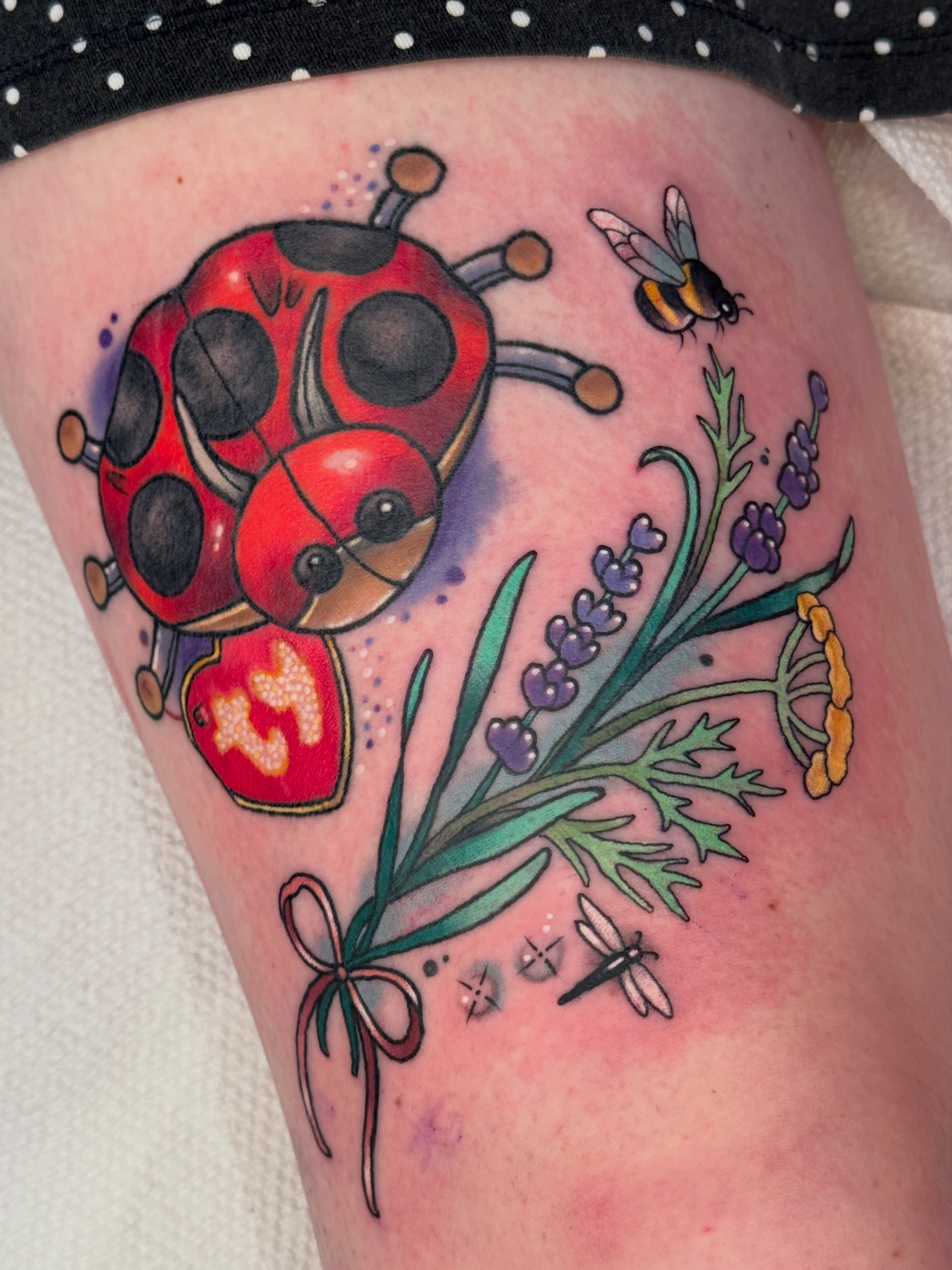 Ladybug and lavender watercolor tattoo on the thigh by Tattoos by Angel Lee