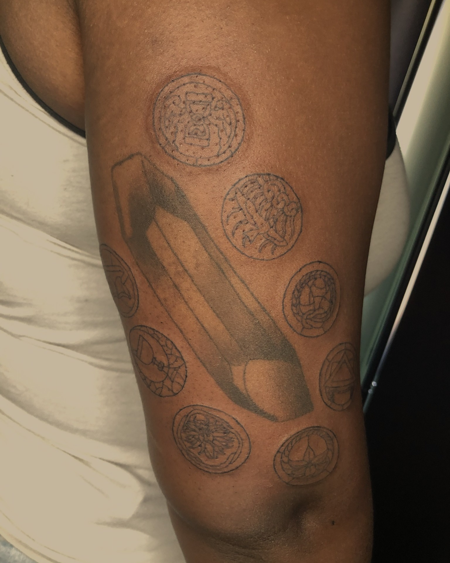 Sword and coins black and grey tattoo on the forearm by Rowan Lee