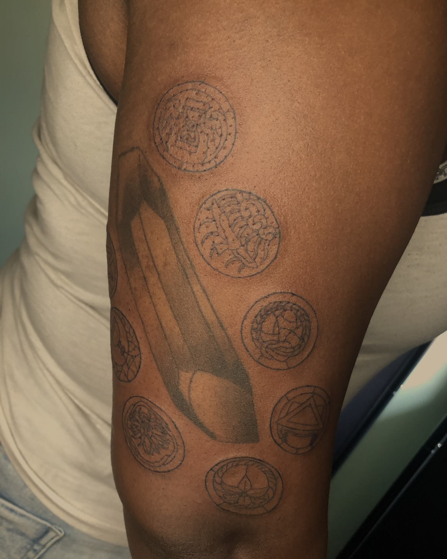 High heel and coins black and grey tattoo on the forearm by Rowan Lee