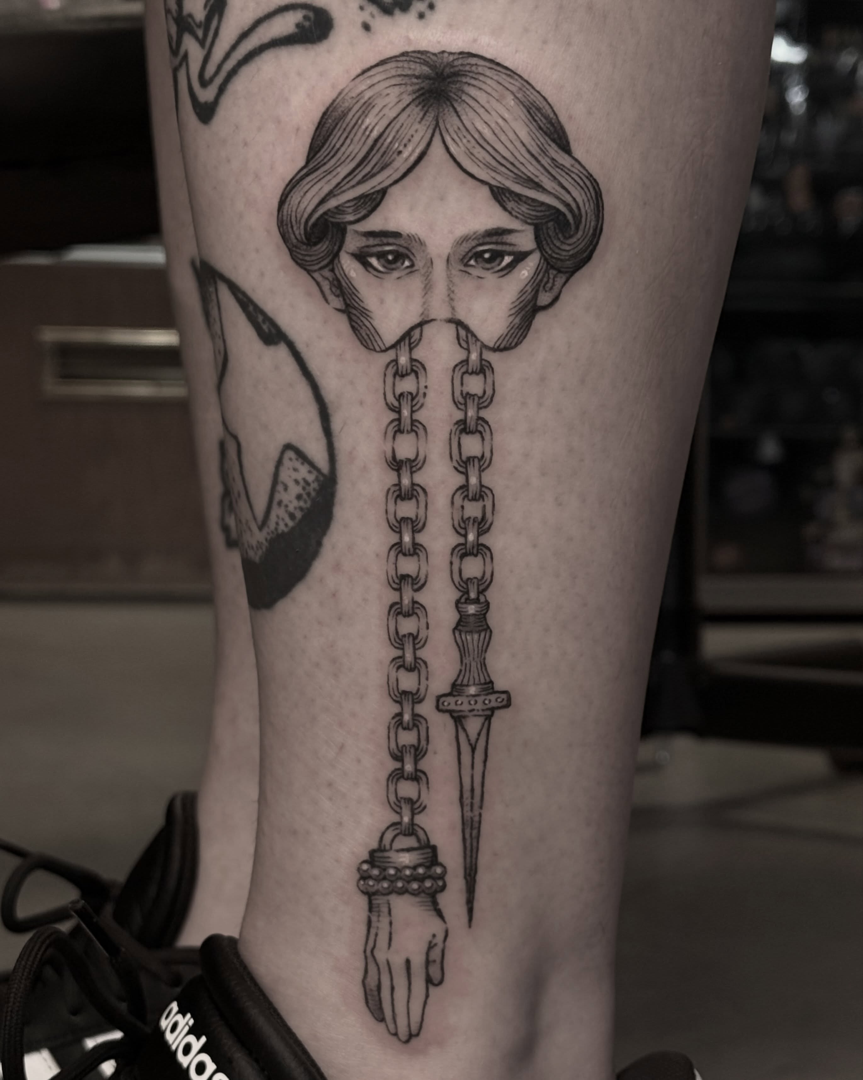 Woman's head with chains and dagger realism tattoo on the forearm by Christian