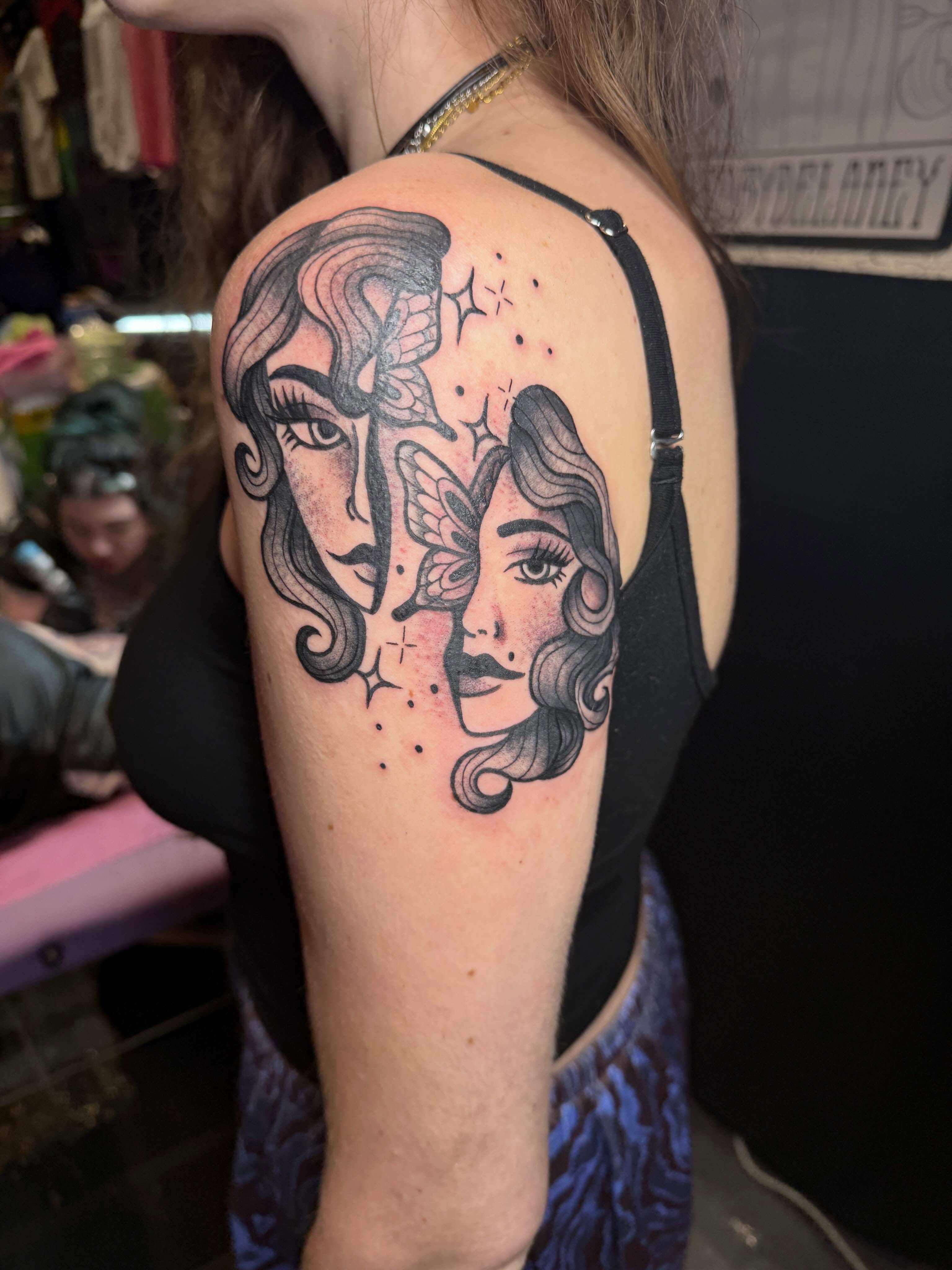 Two faces black and grey tattoo on the shoulder by Abby