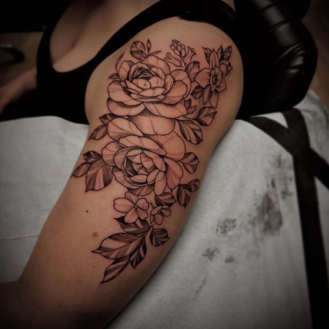 Floral bouquet black and grey tattoo on the upper arm by Sebastian Livingston