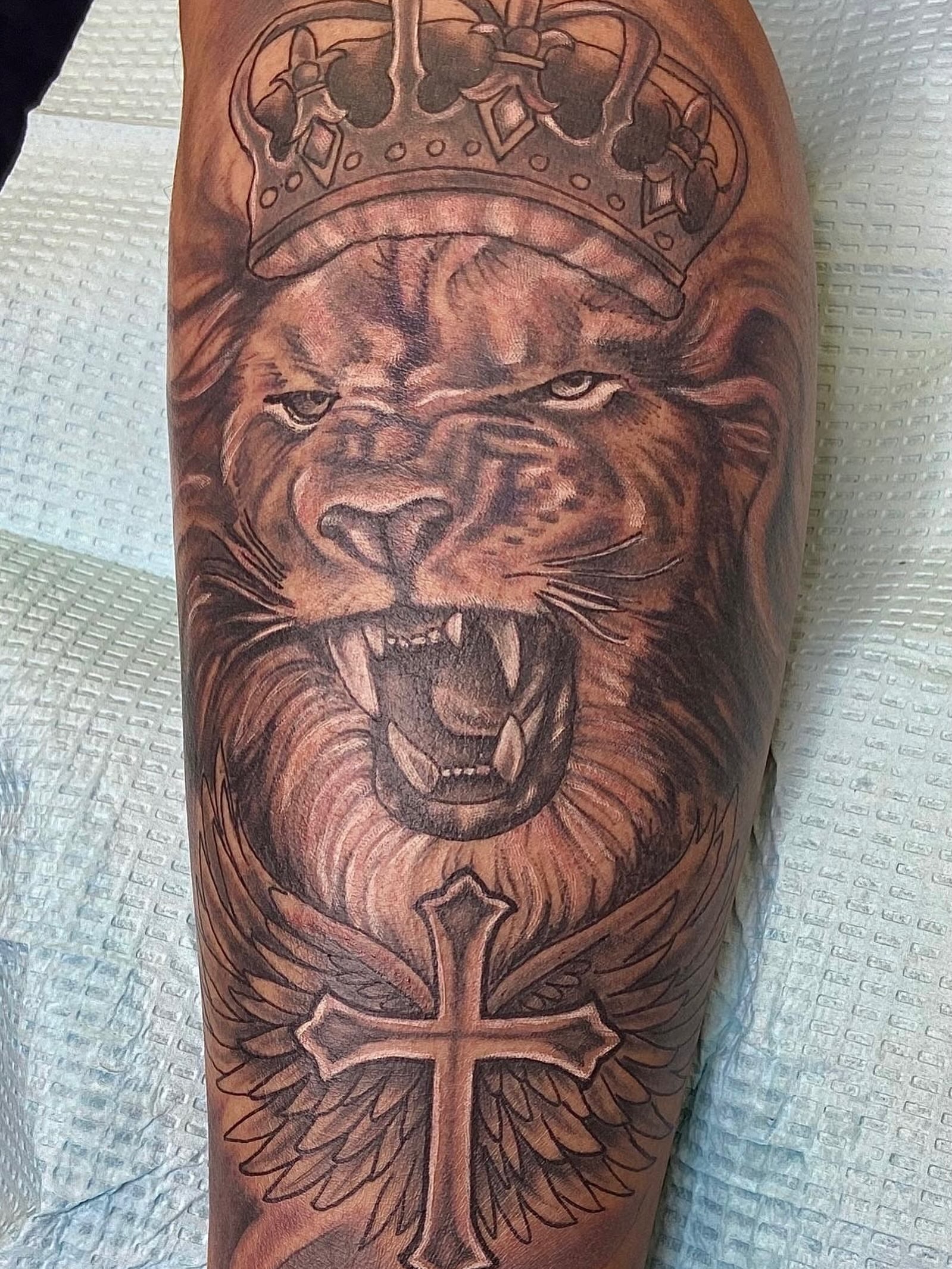 Lion with crown realism tattoo on the forearm by Christian Goines, Memphis, Tennessee