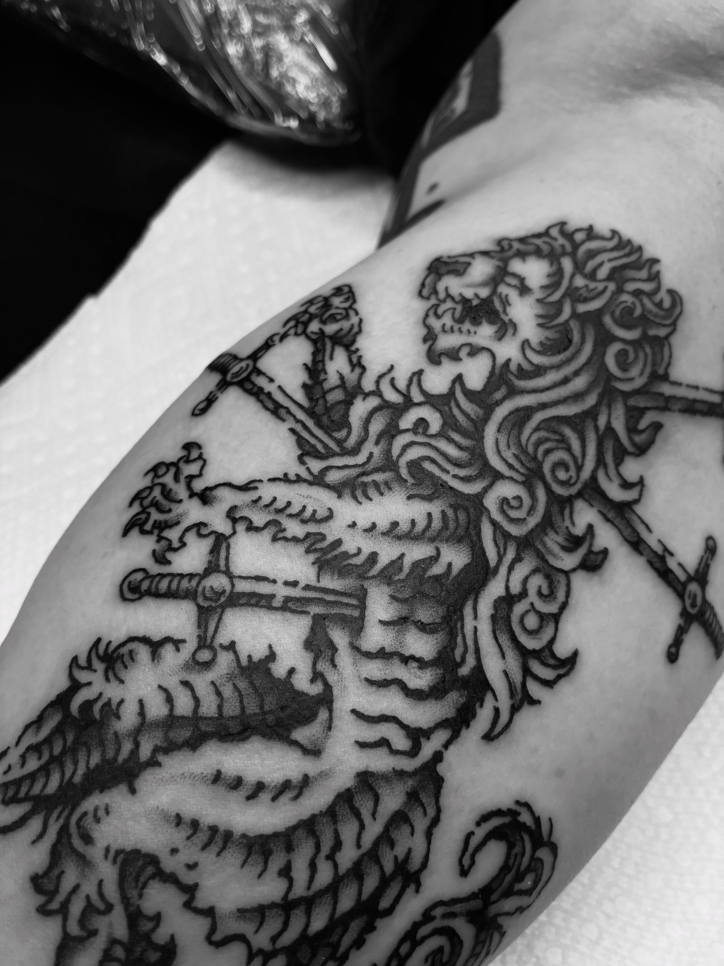 Lion and swords black and grey tattoo on the shoulder by Zachary R Bobkoff