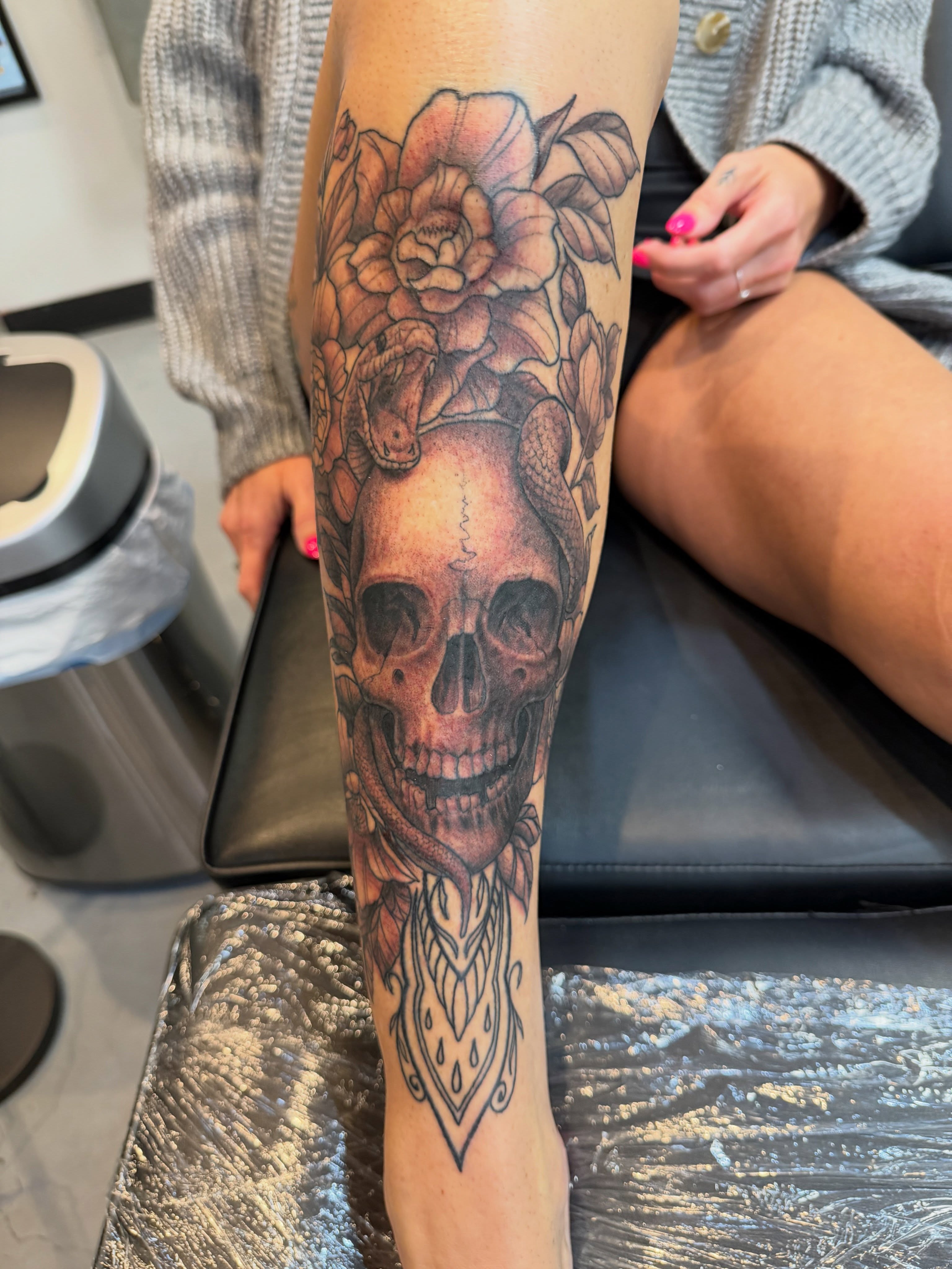 Skull with flowers realism tattoo on the forearm by steven