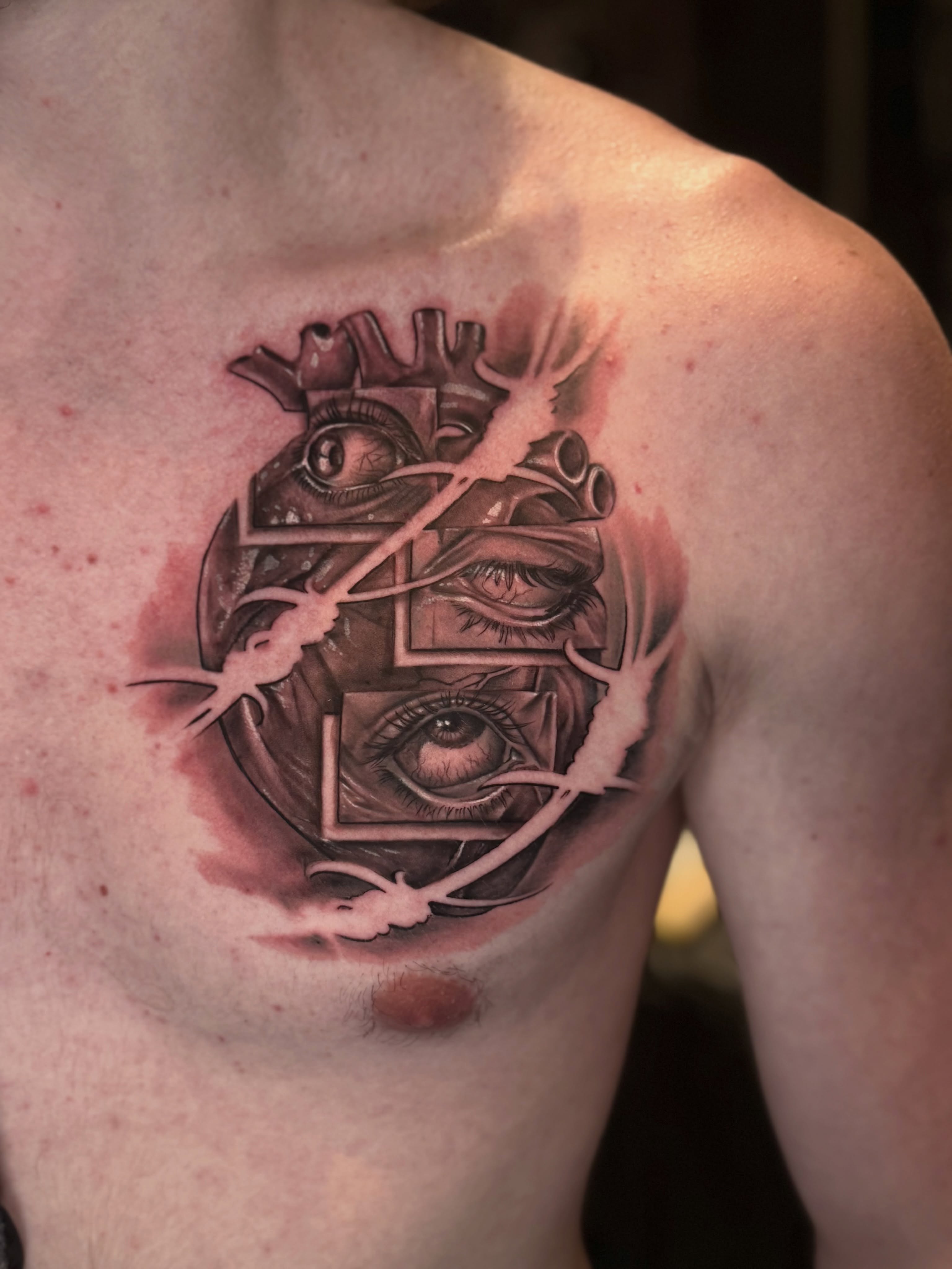 Heart with eyes geometric tattoo on the chest by Indiana Tattoo Artist