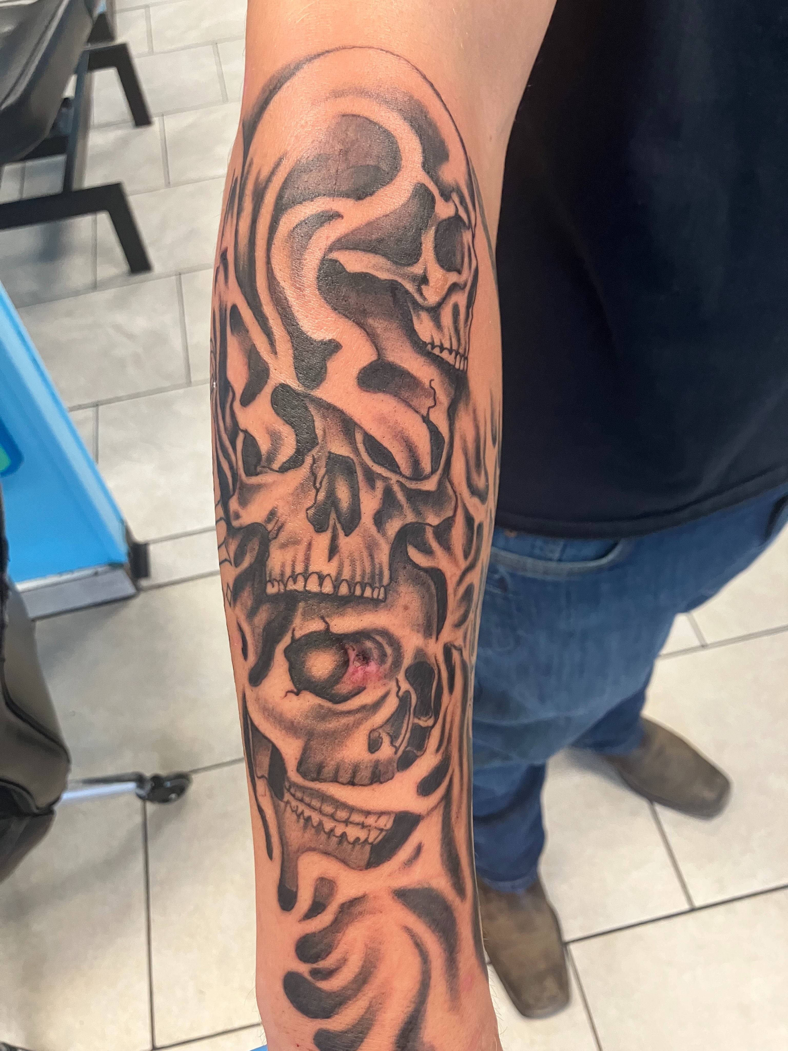 Flaming skull realism tattoo on the forearm by Bryant Johnson