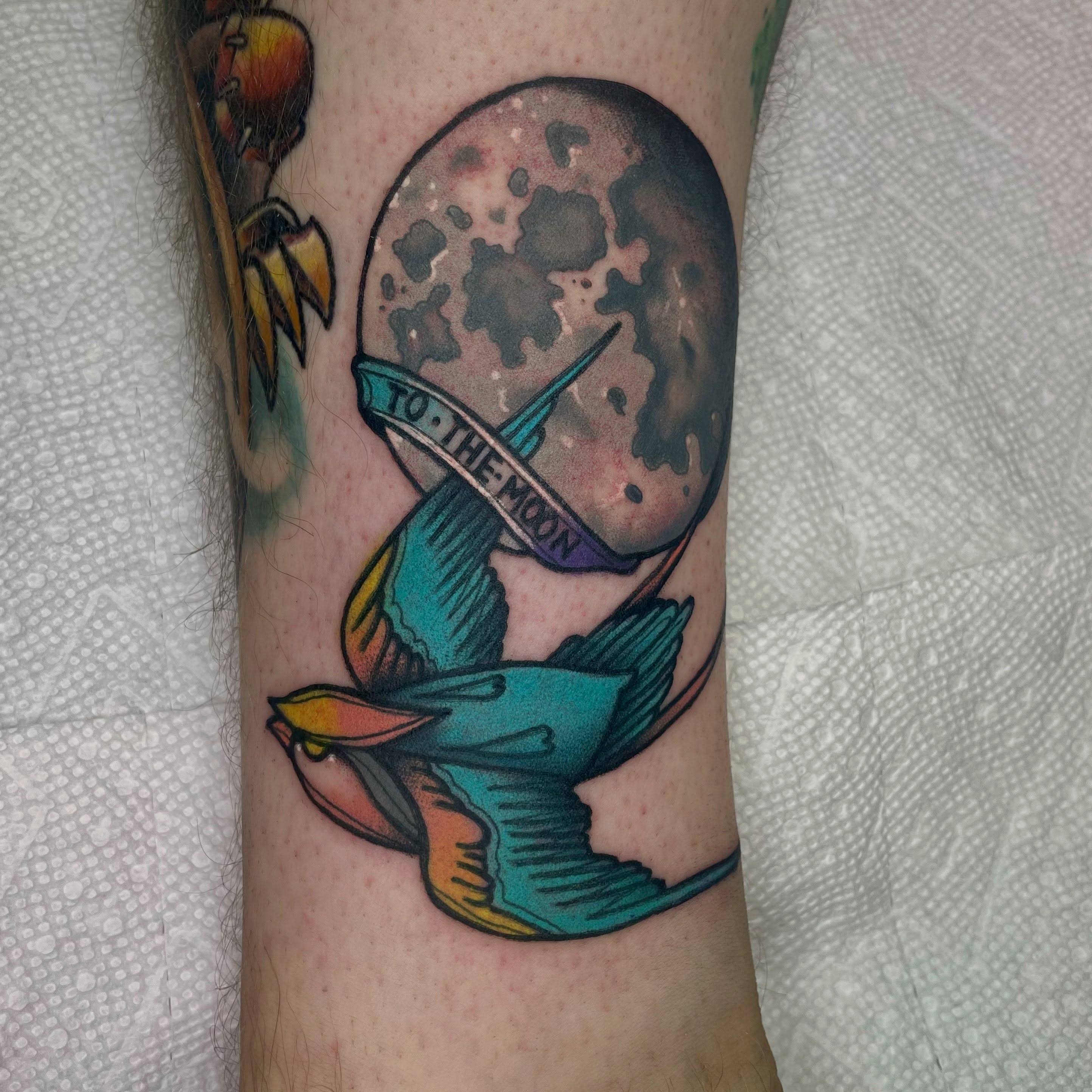 Bird flying towards moon American traditional tattoo on the forearm by Robert Morrow