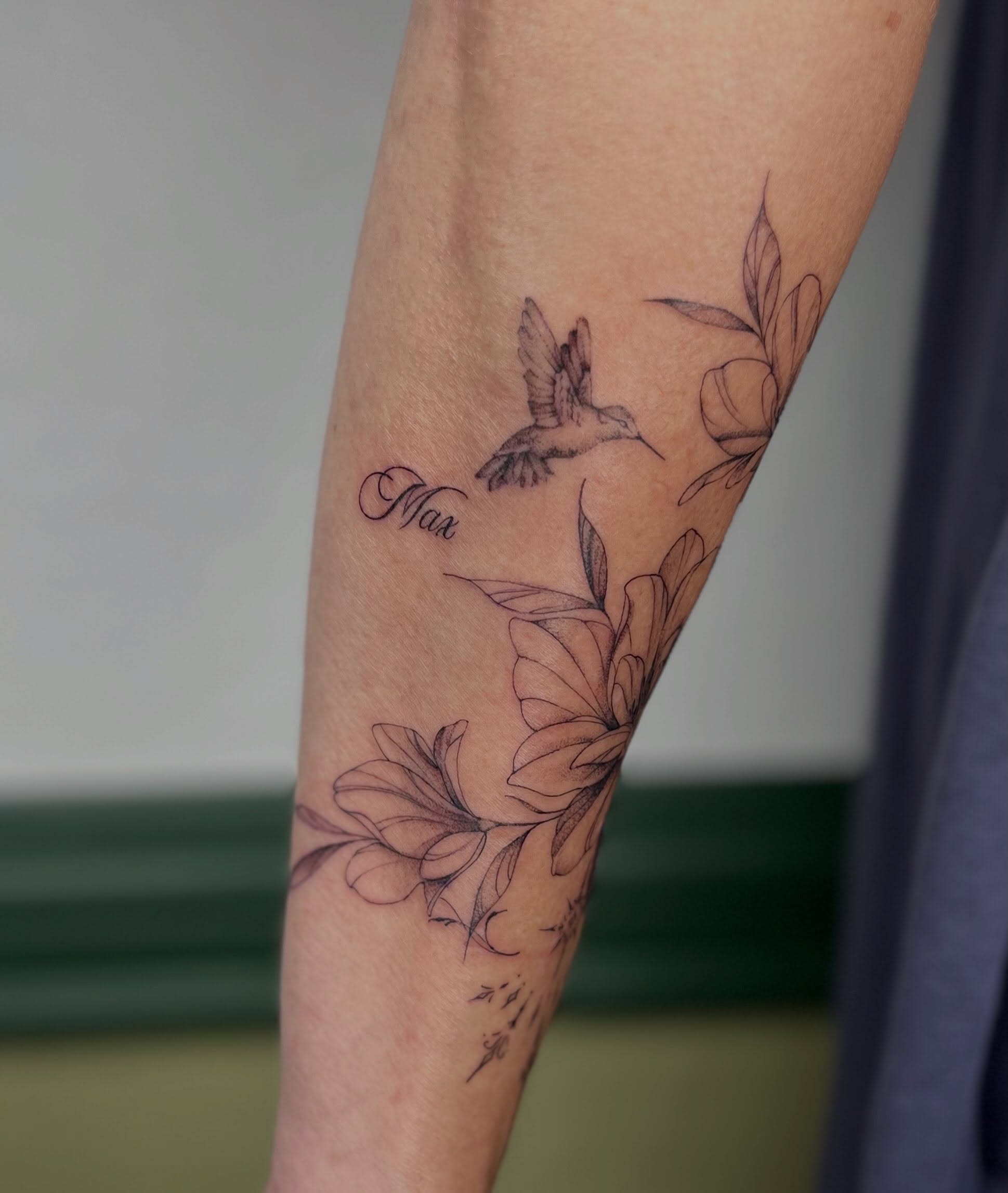 Hummingbird and flowers black and grey tattoo on the forearm by Ash F