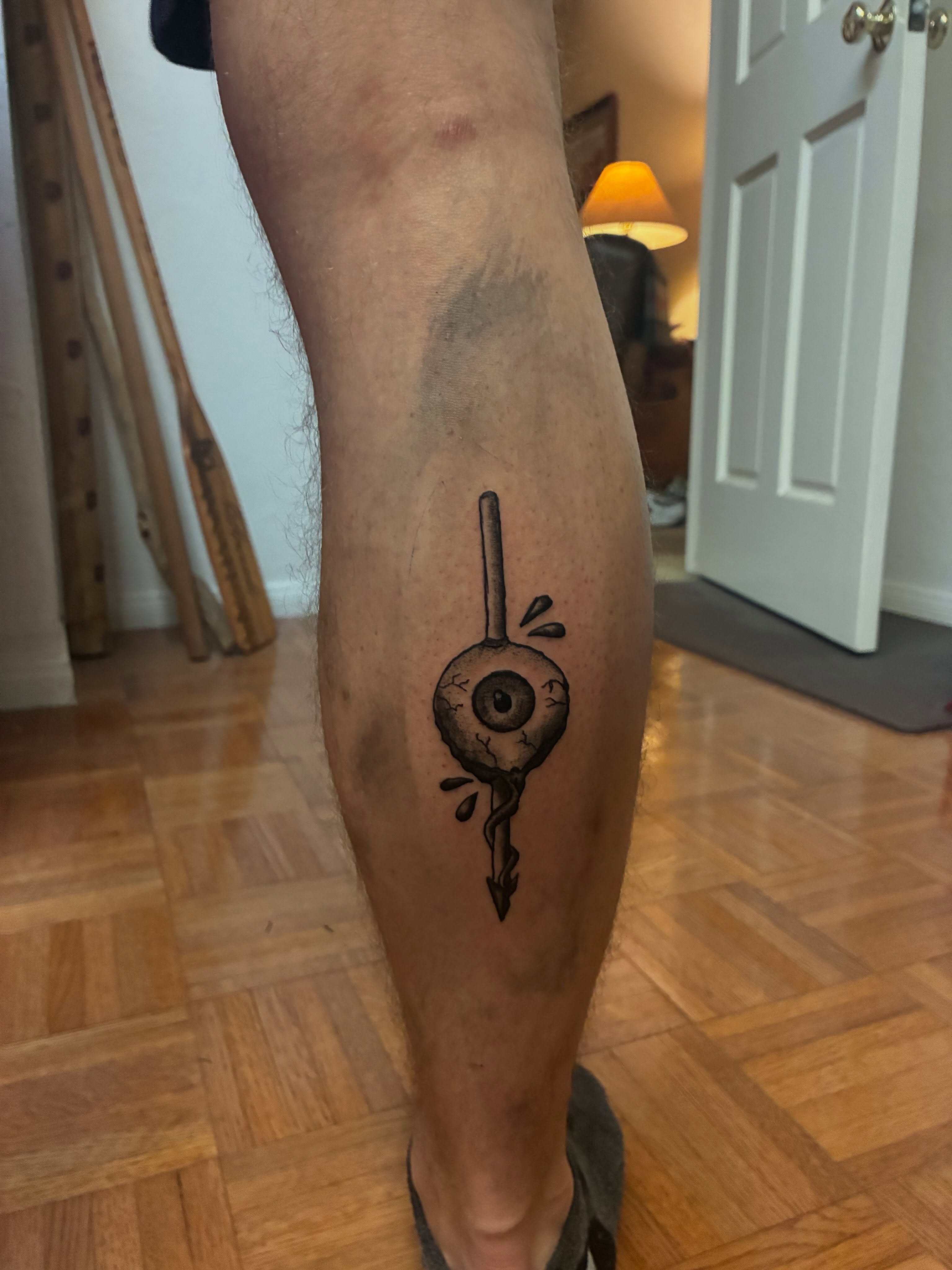 Eyeball with arrow black and grey tattoo on the calf by Resse