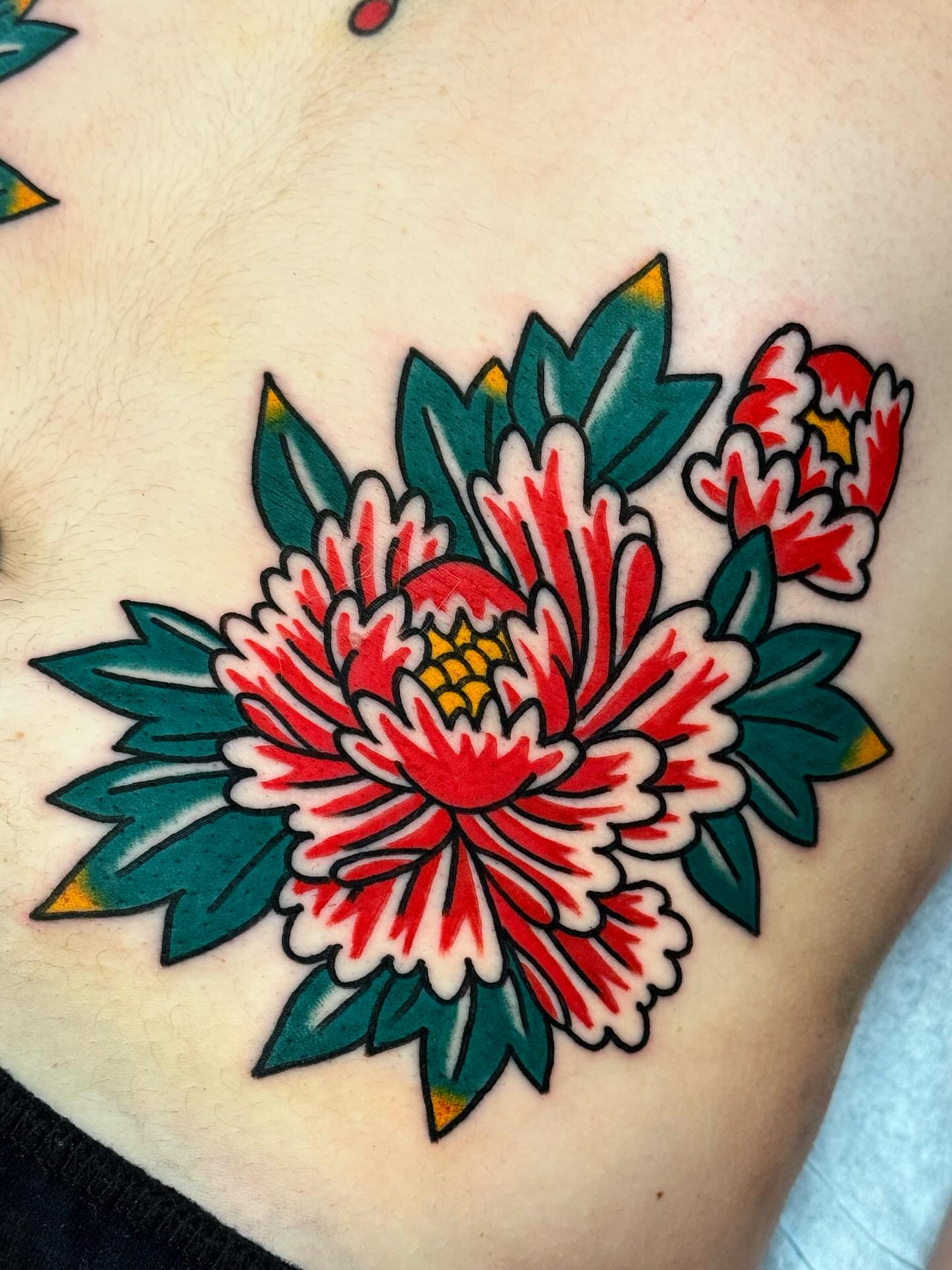 Chrysanthemum American traditional tattoo on the chest by Bryce Shearer