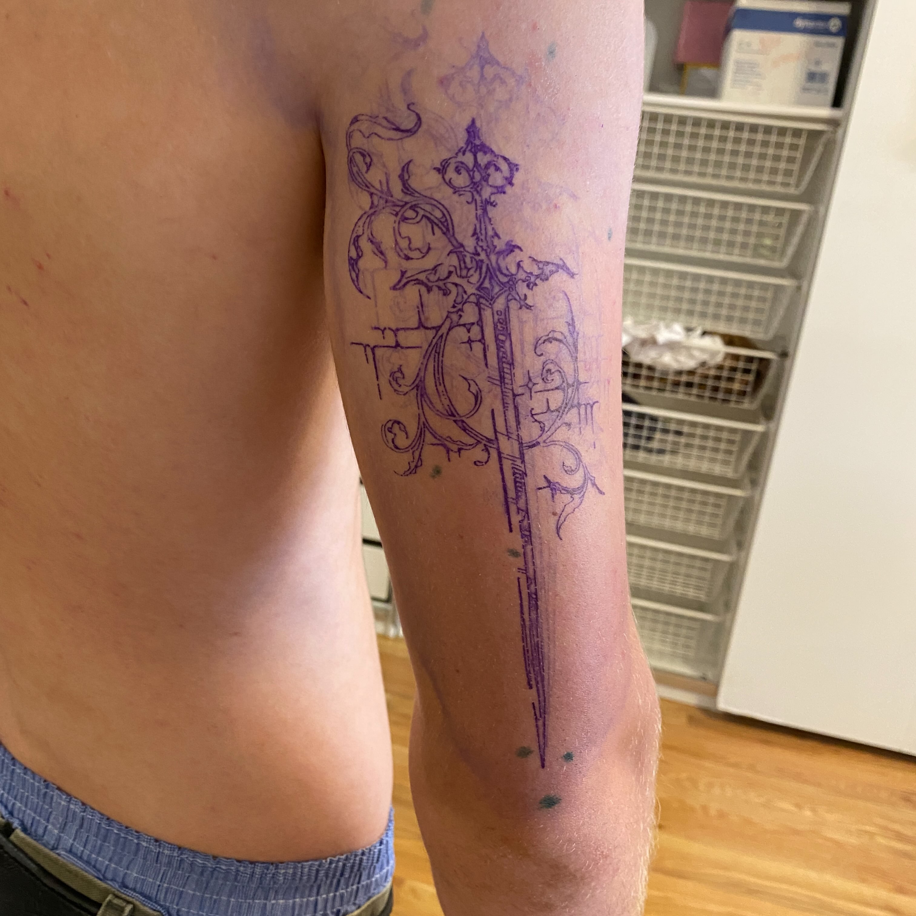 Sword and floral ornamentation ornamental tattoo on the forearm by Clara