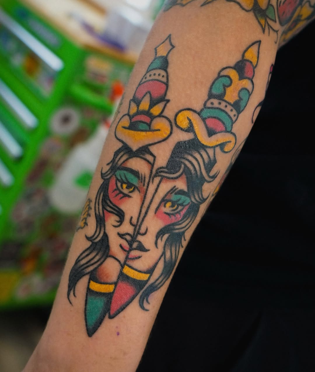 Divided face American traditional tattoo on the forearm by Emily Devenz