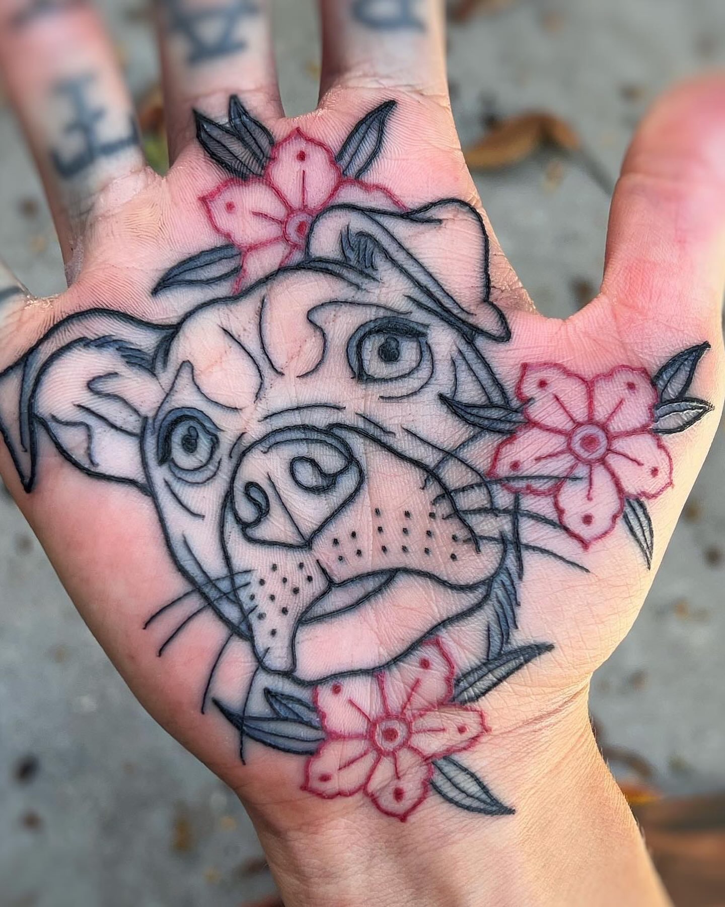 Bulldog with flowers American traditional tattoo on the hand by Mark Walker