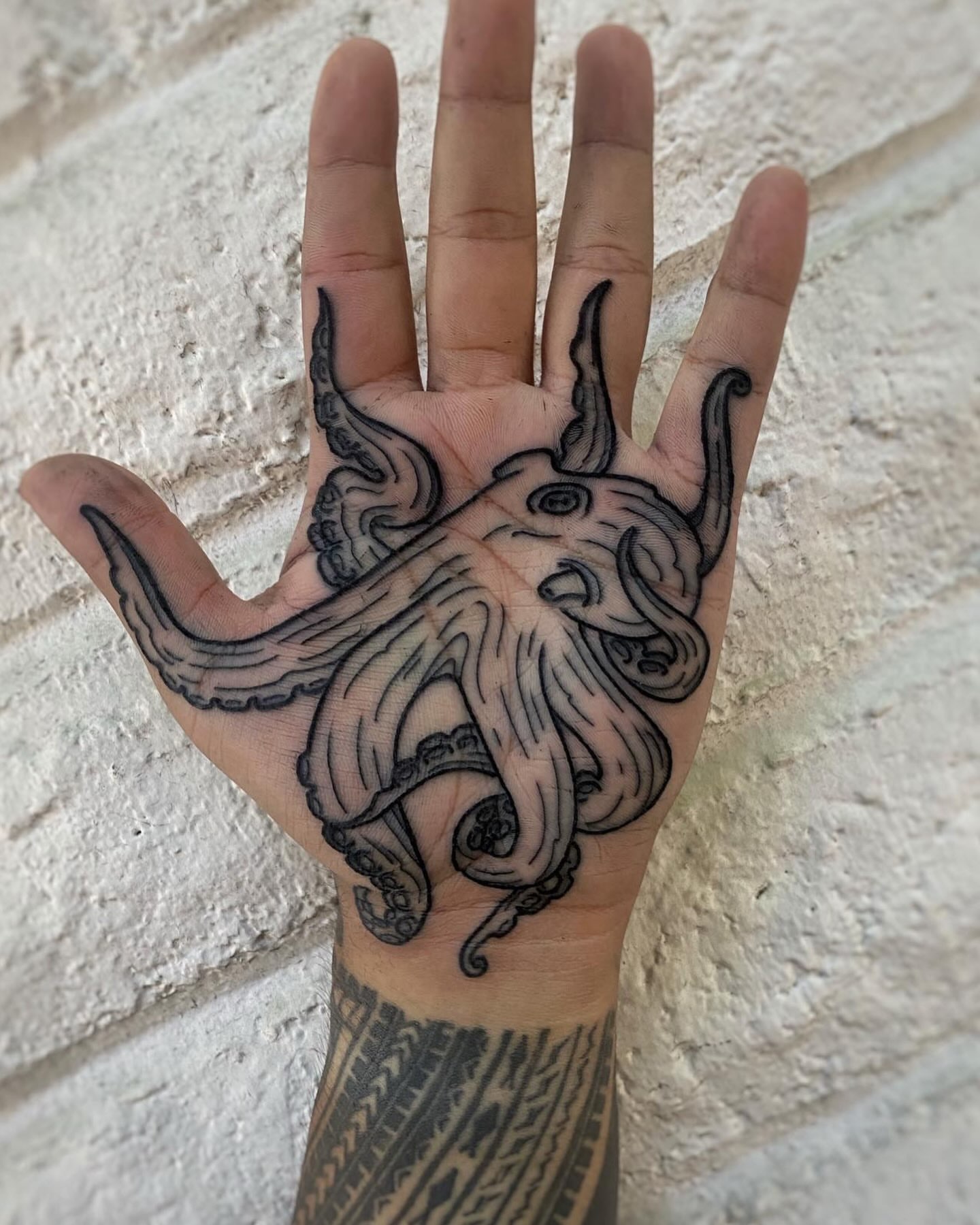 Octopus black and grey tattoo on the hand by Mark Walker