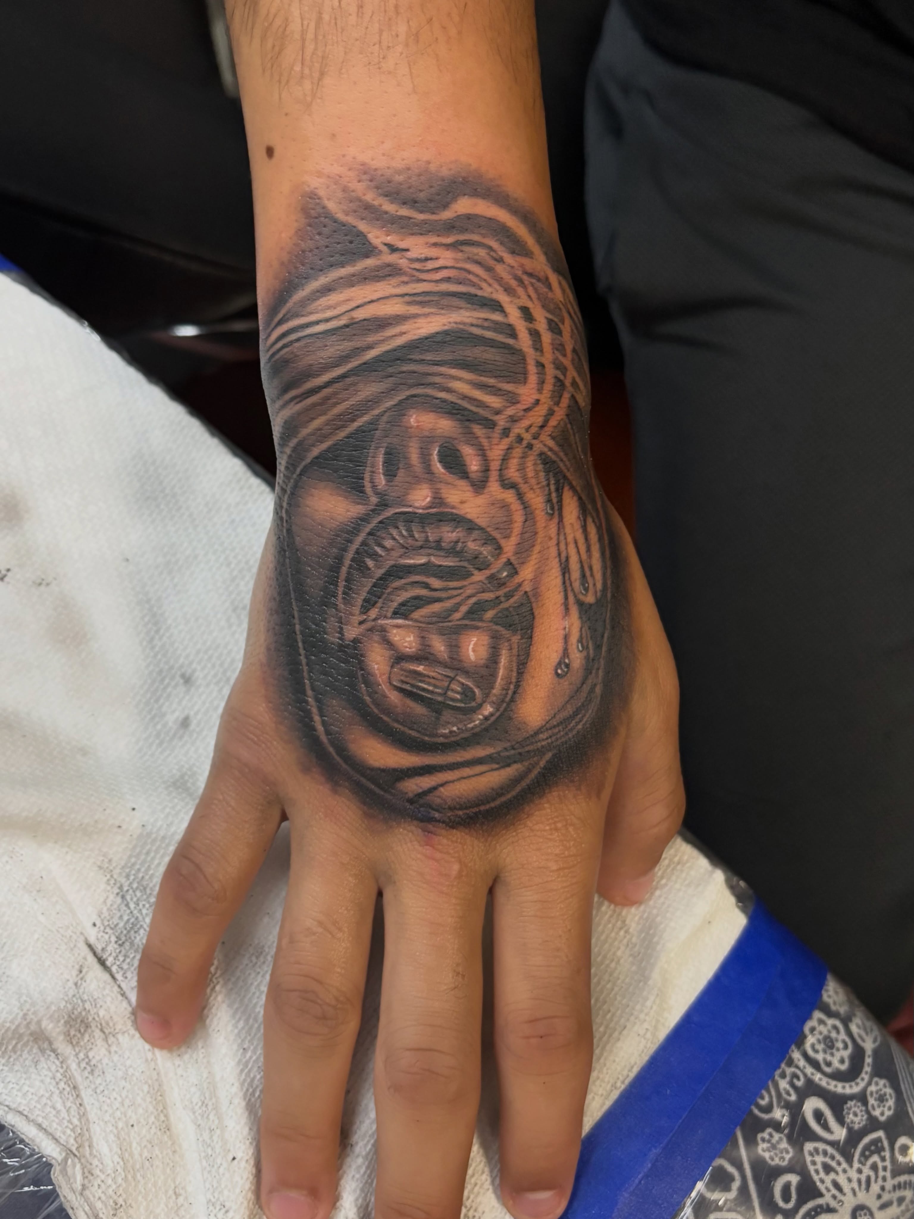 Horror mask dark realism tattoo on the hand by @tattoosbyadrian