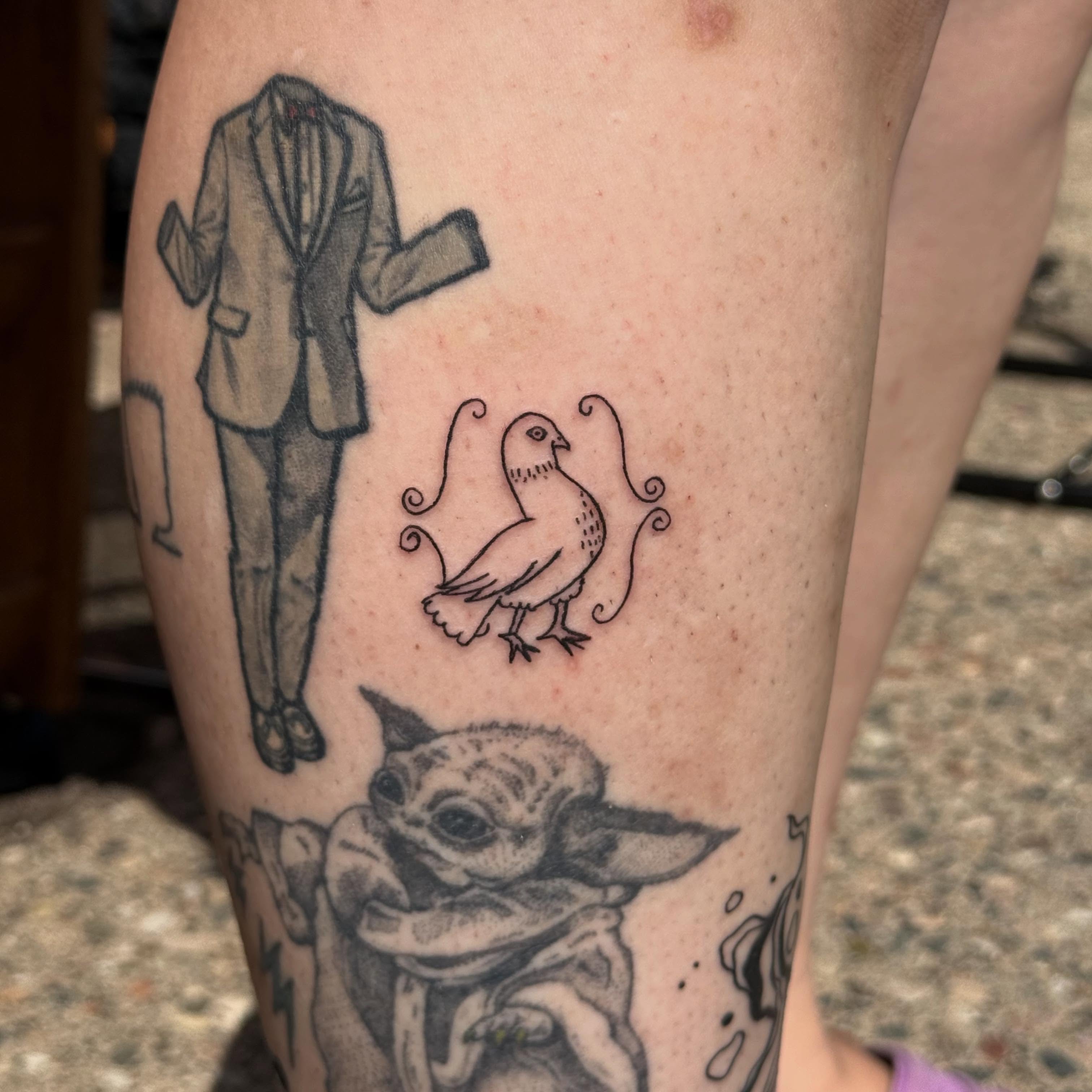 Suit, bird, baby yoda black and grey tattoo on the leg by house0fsleep 💤