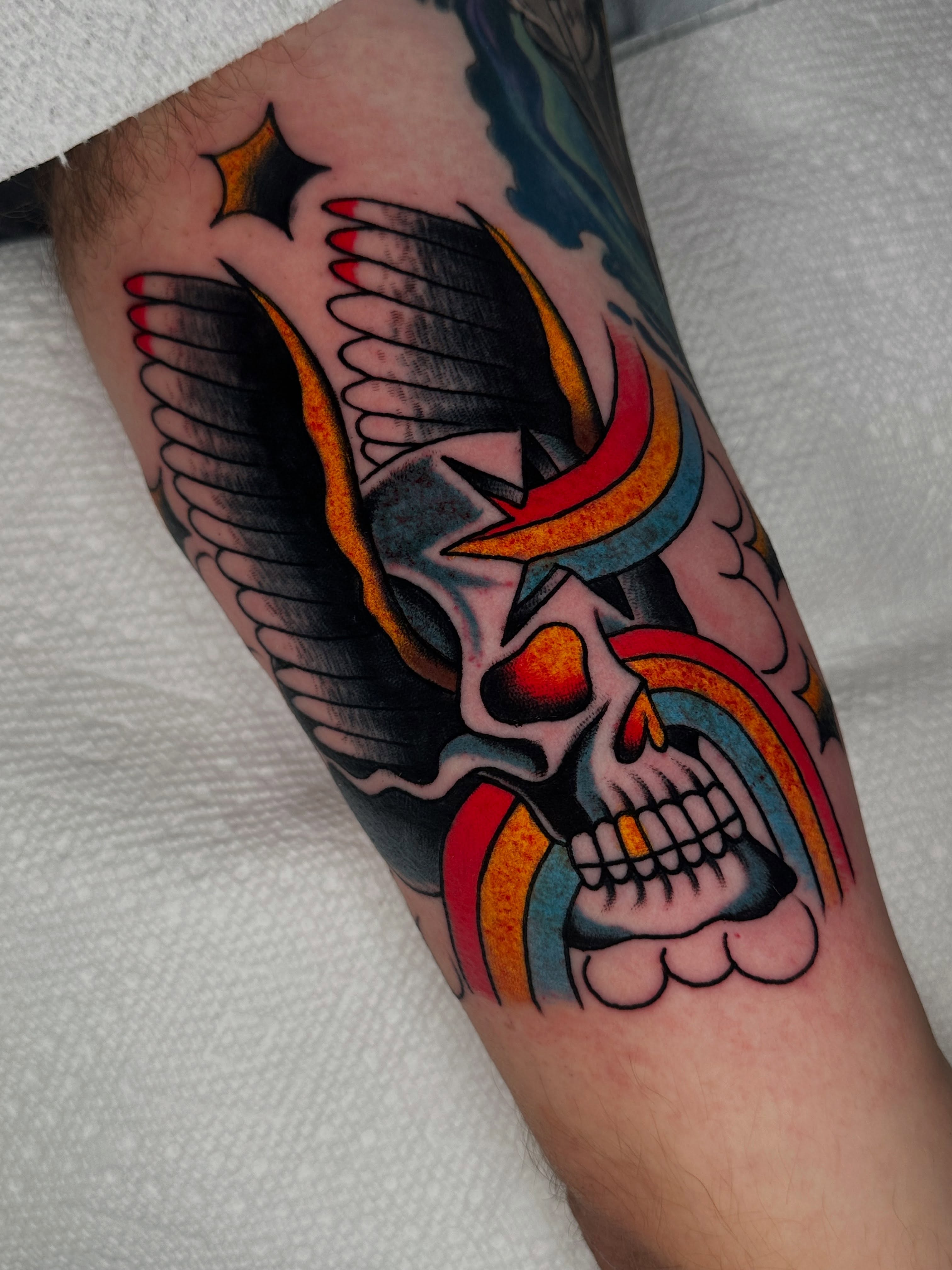 Skull with wings American traditional tattoo on the forearm by Spencer Crawford, Speedway, Indiana