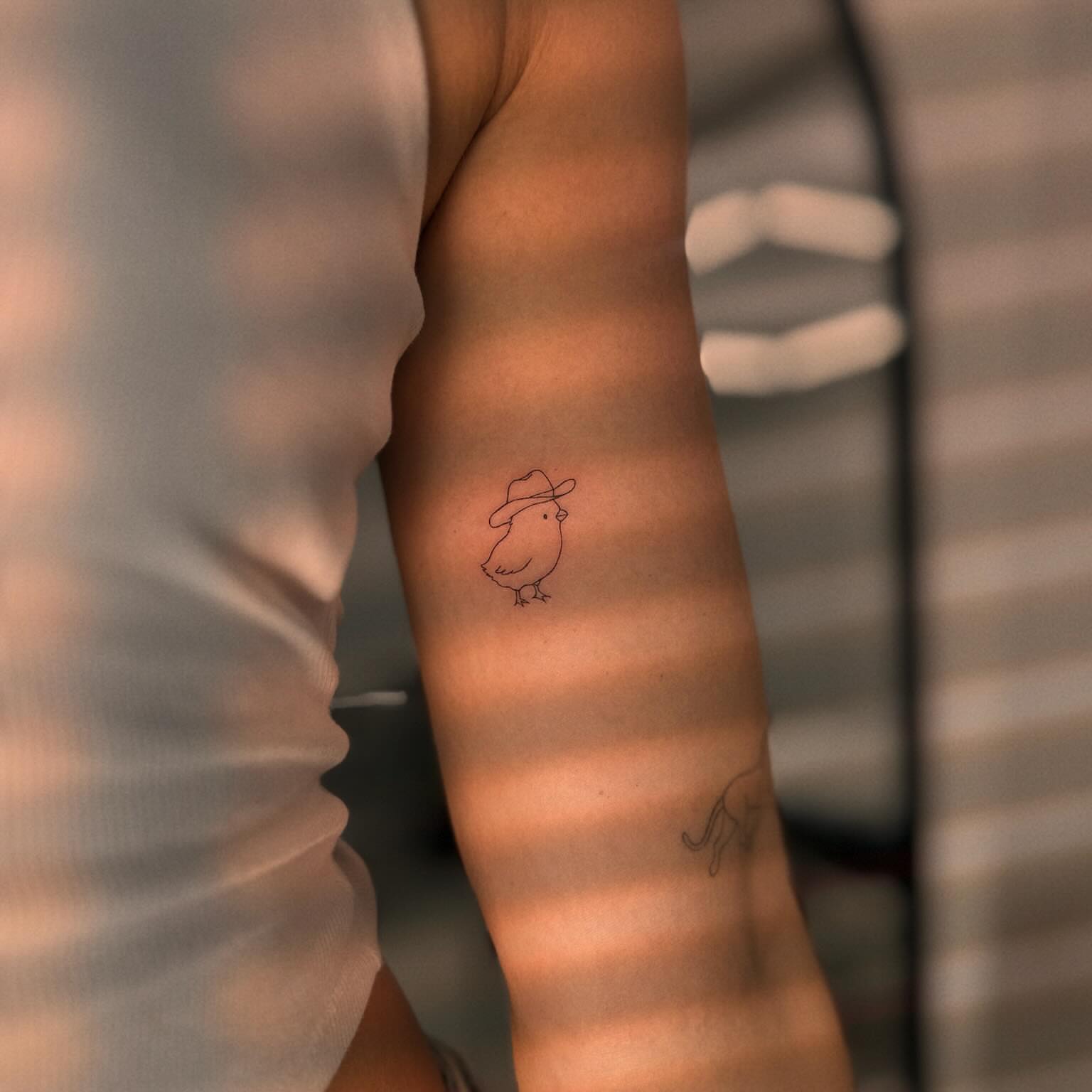 Chicken wearing hat minimalist tattoo on the forearm by Ellie