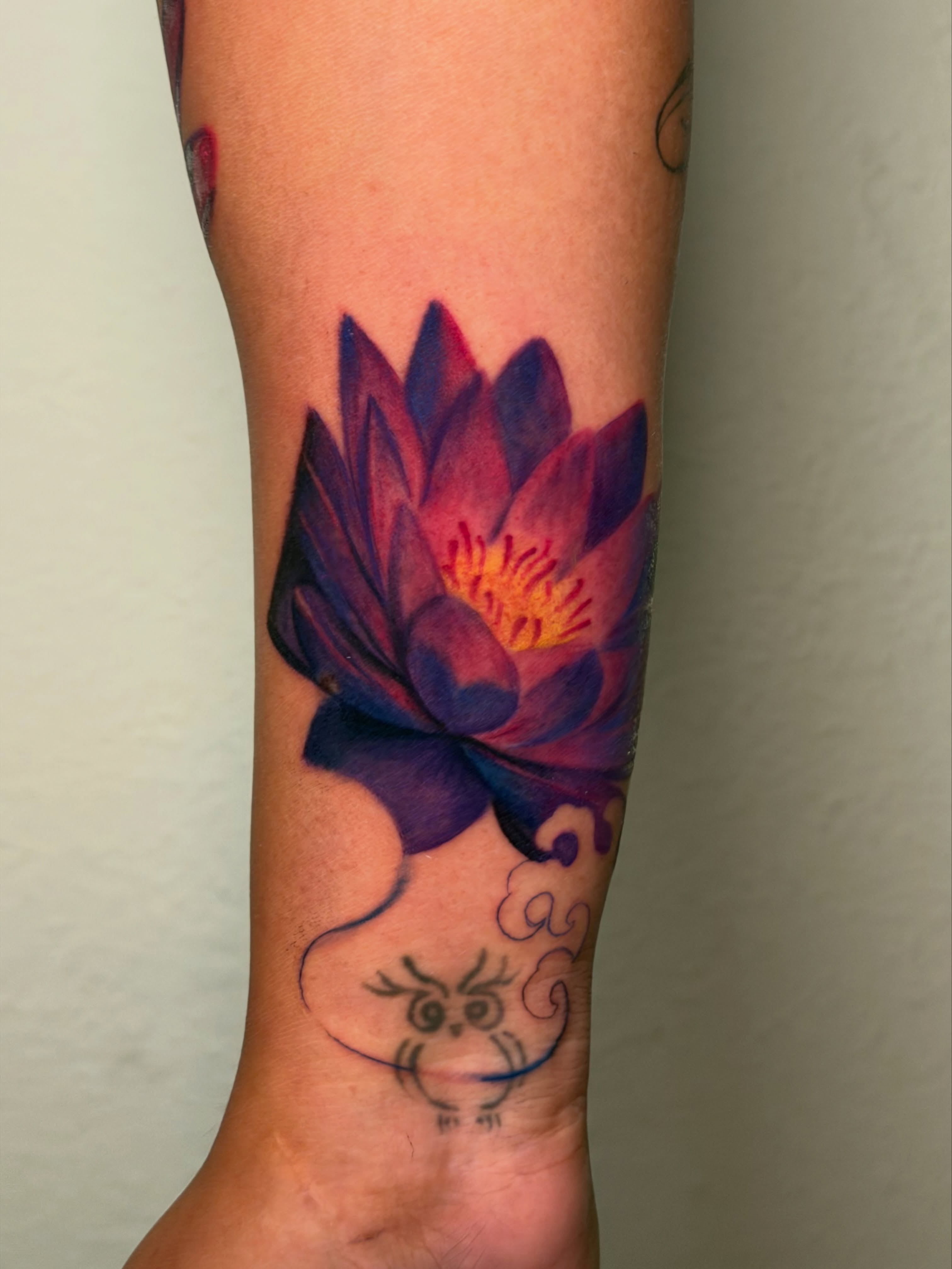 Lotus flower watercolor tattoo on the forearm by Kiki Tattoos😈