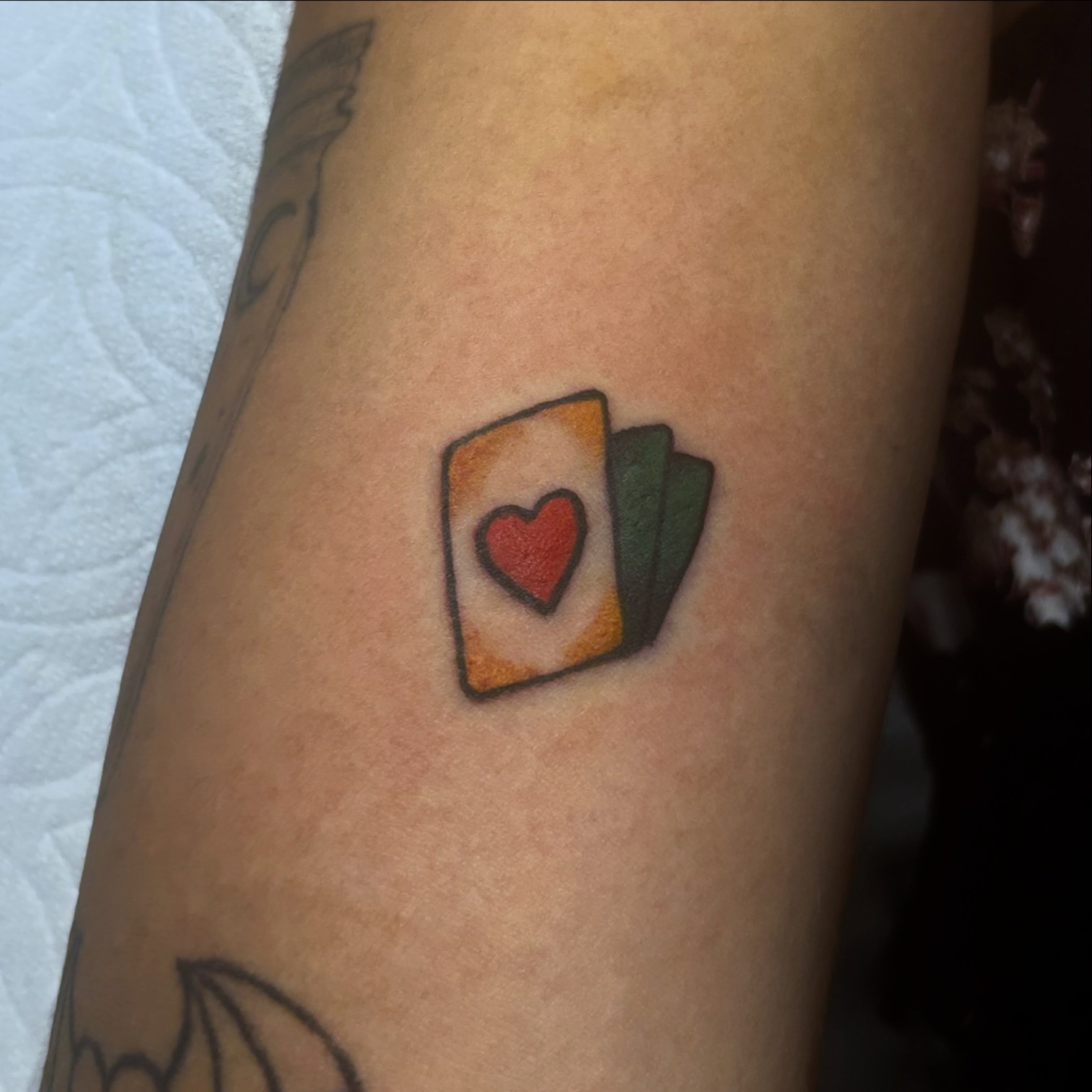 Playing cards realism tattoo on the forearm by Tawni Bender