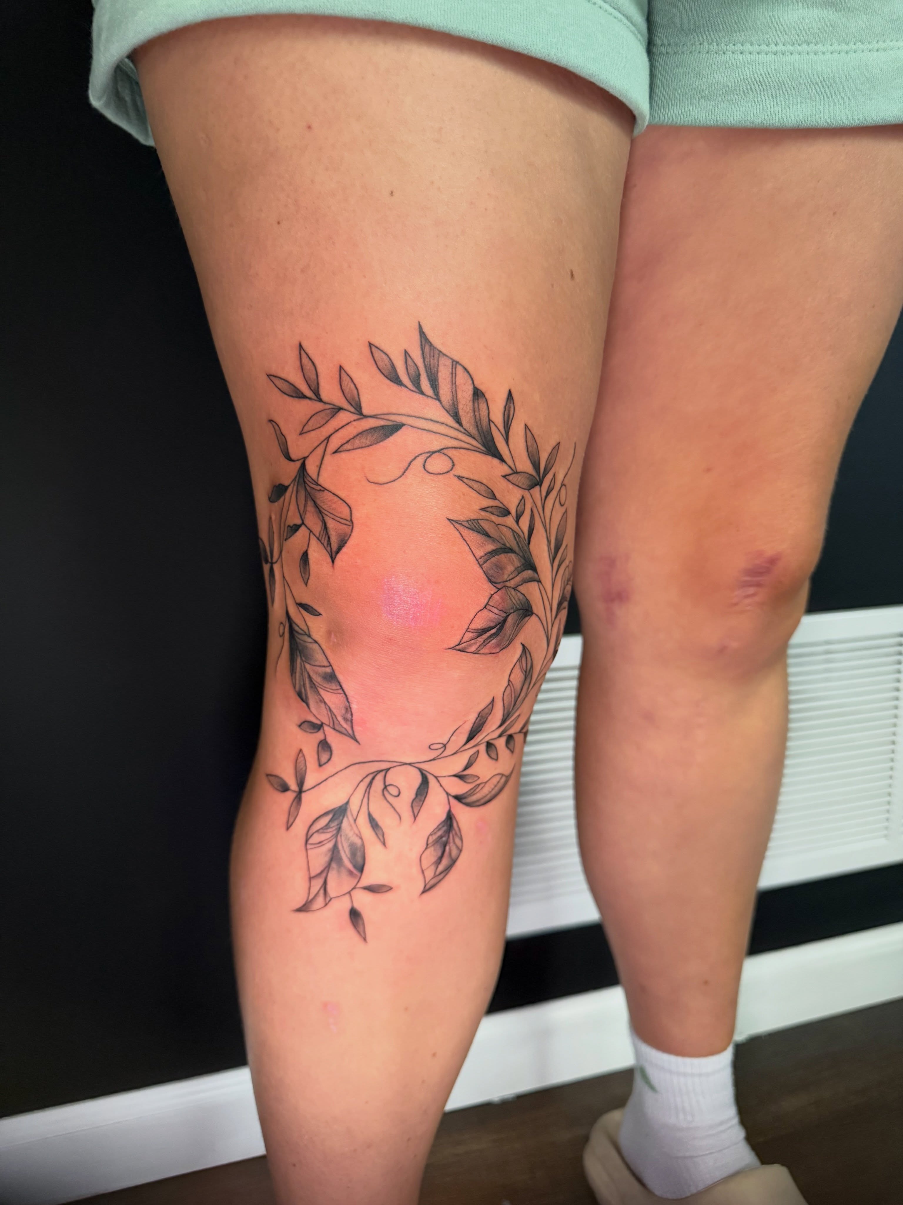Wreath black and grey tattoo on the thigh by Michelle Balhan