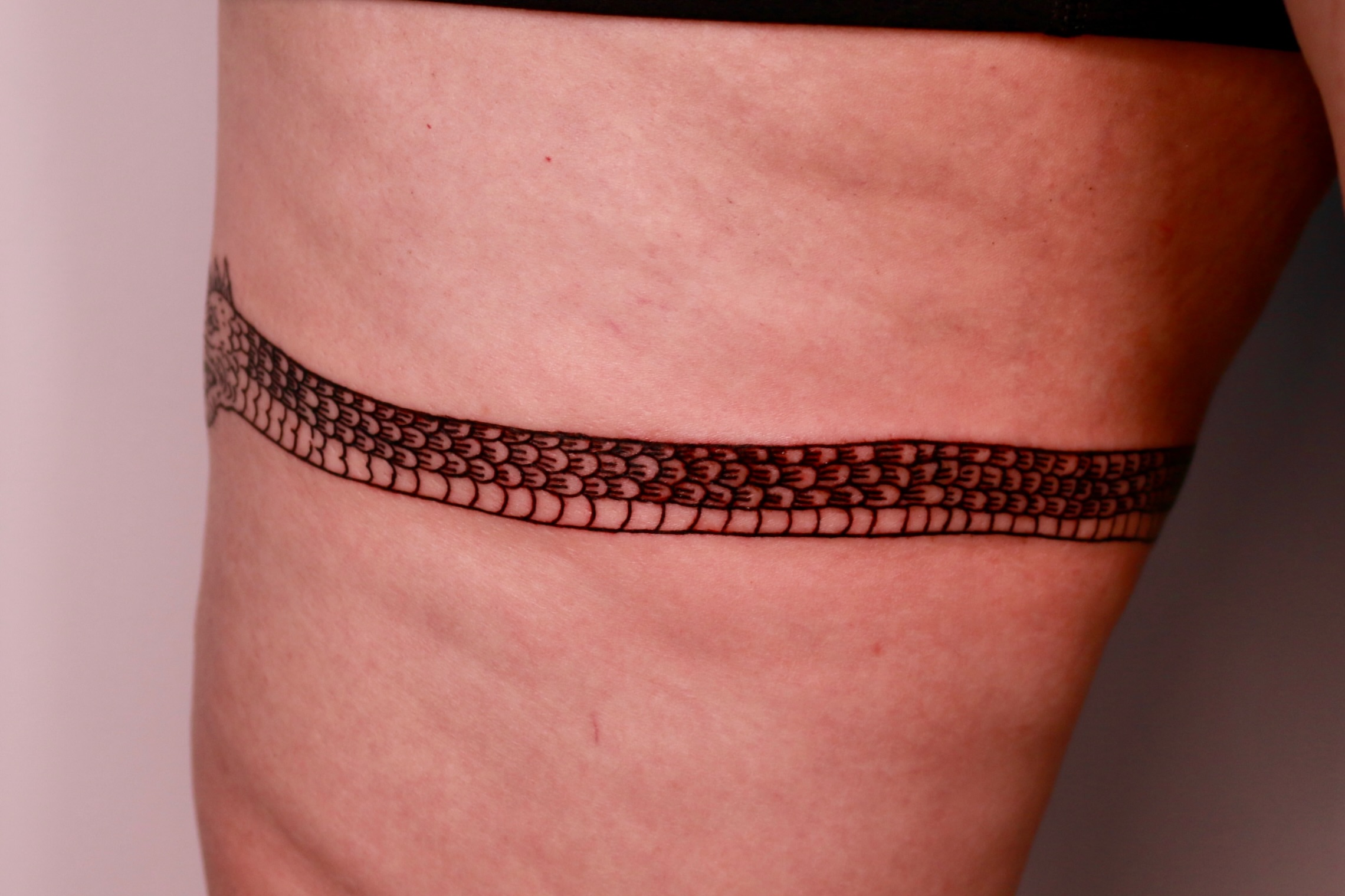 Snake scales black and grey tattoo on the thigh by Mike