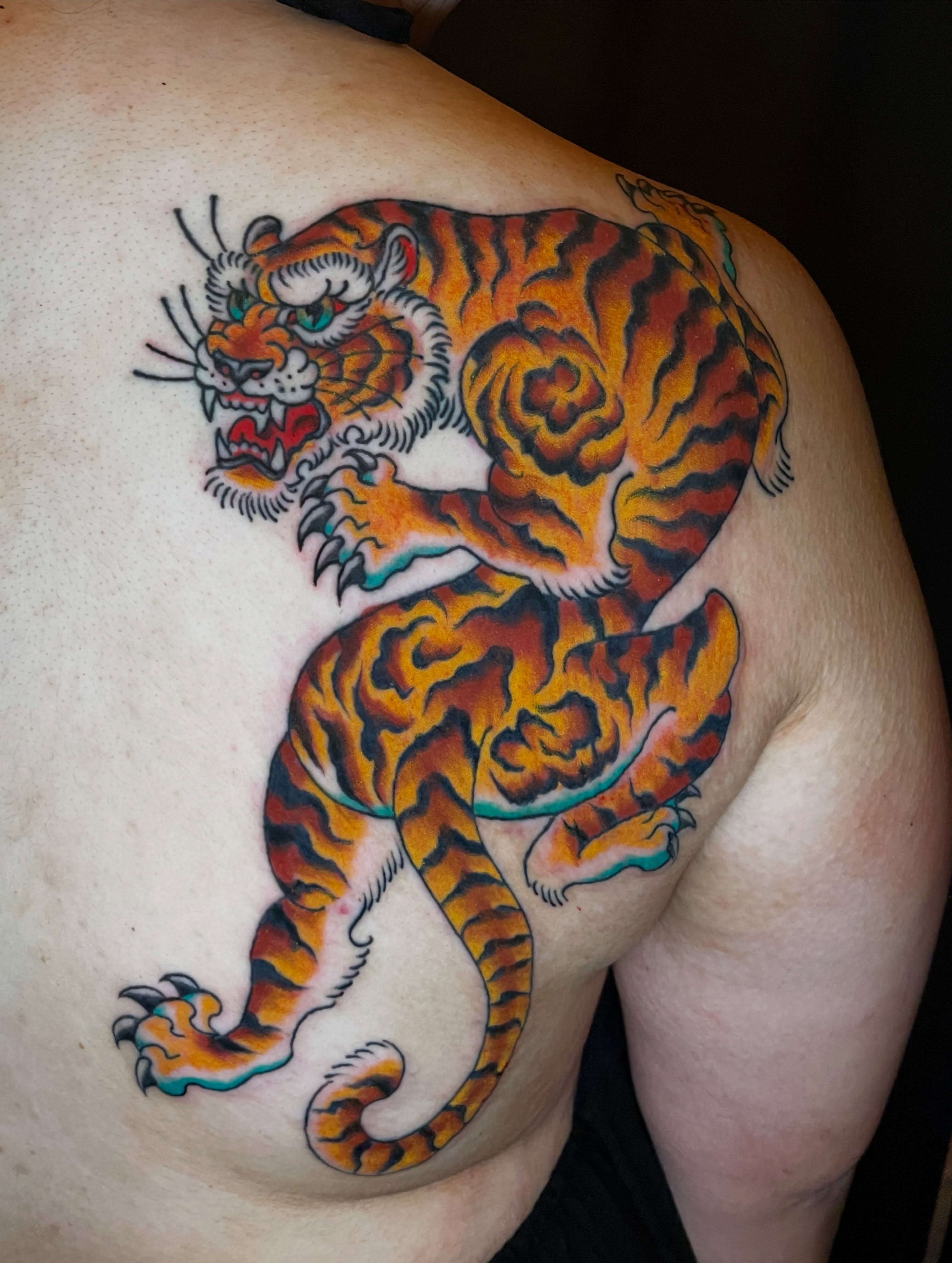 Tiger American traditional tattoo on the shoulder by Nick Wallin