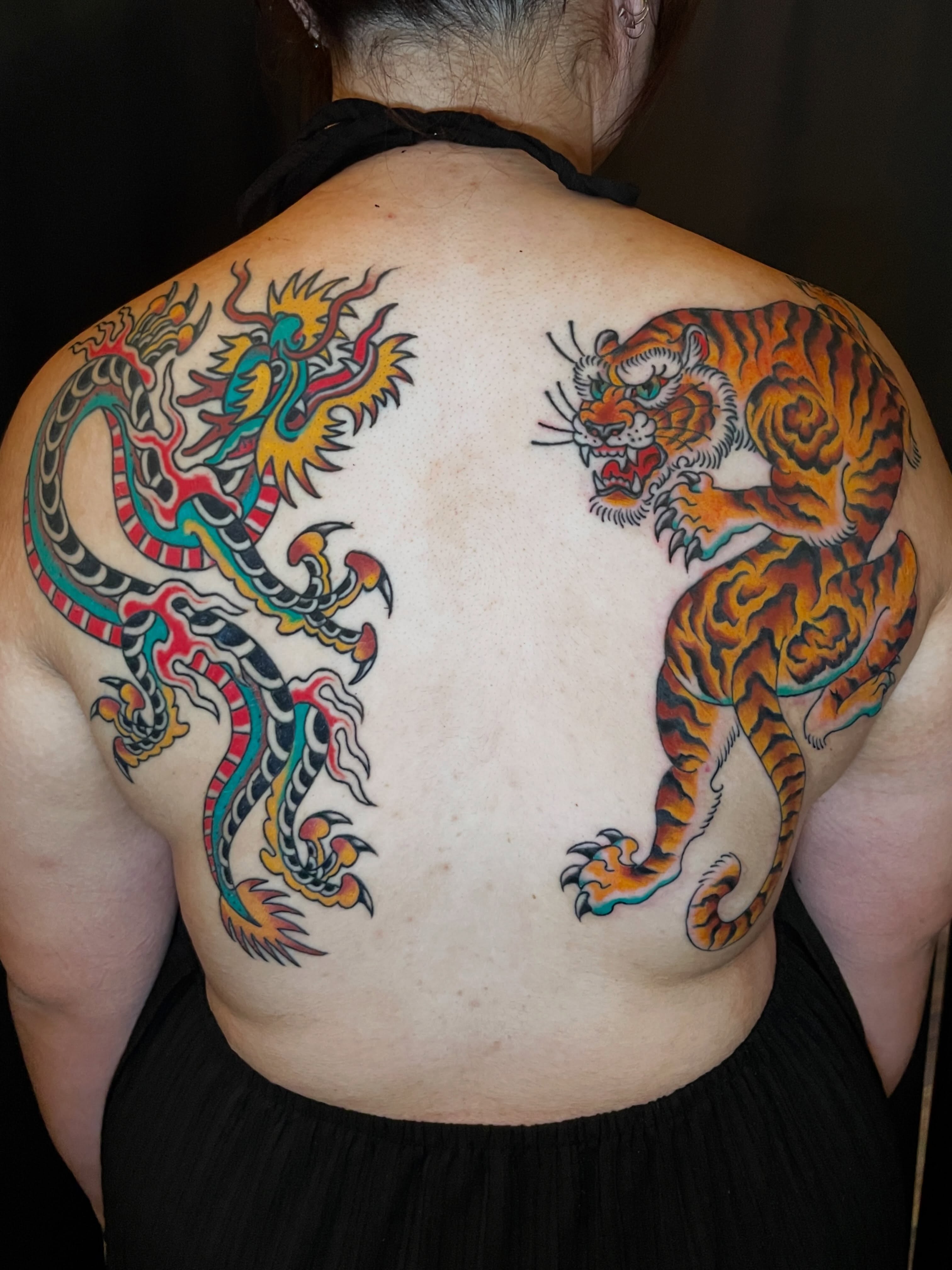 Dragon and tiger American traditional tattoo on the back by Nick Wallin