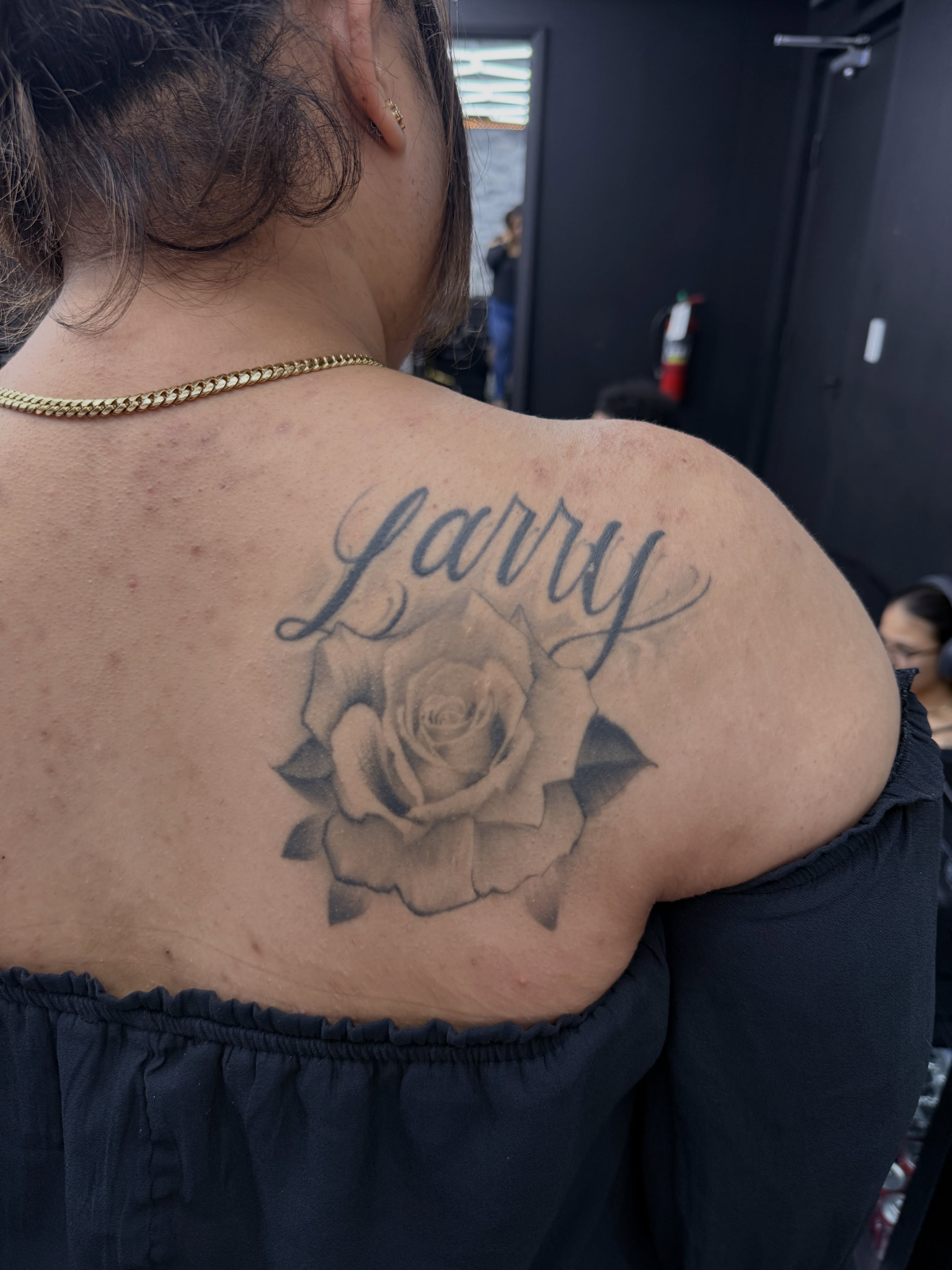 Rose and name black and grey tattoo on the shoulder by chris tattoo