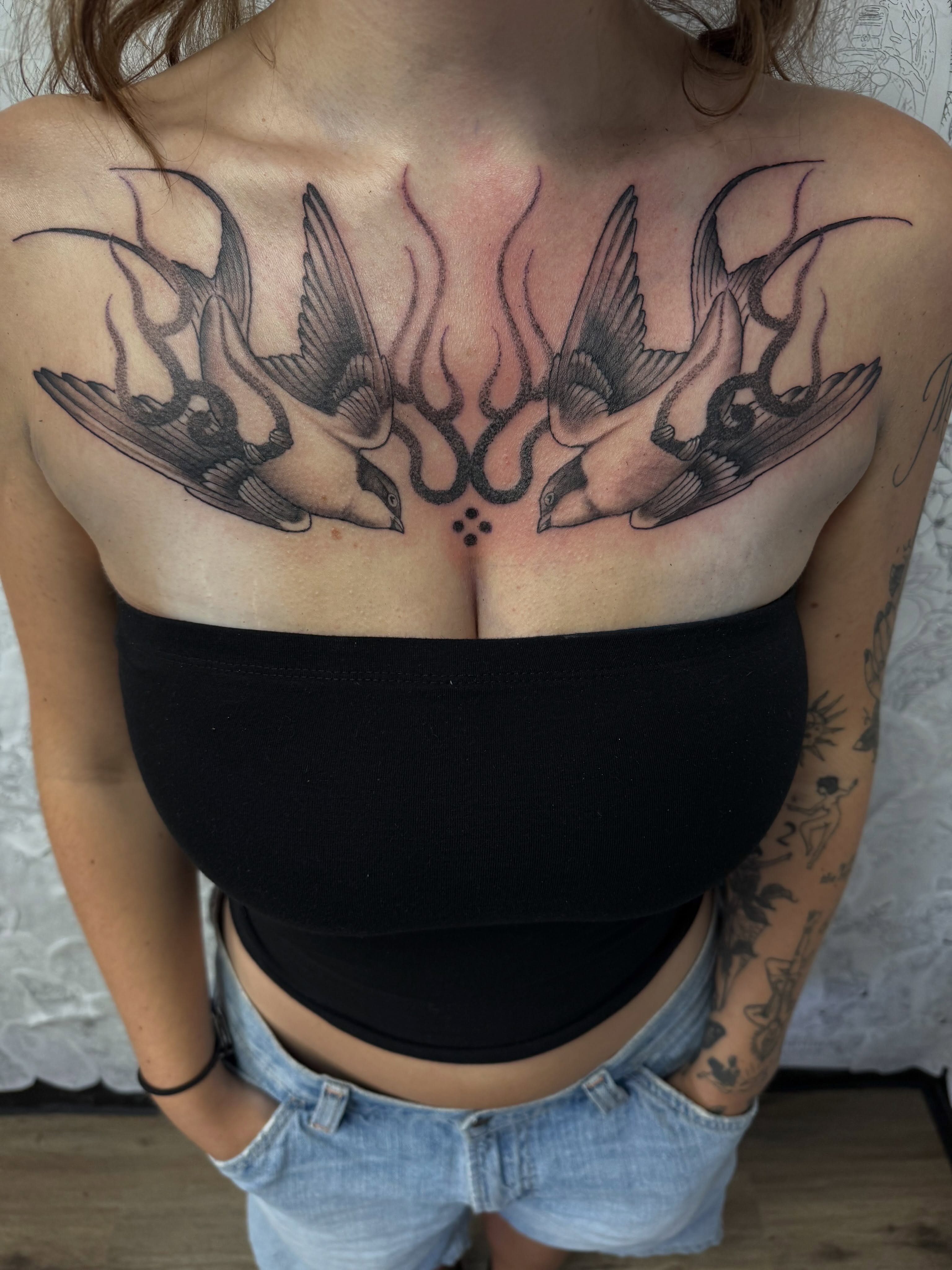 Swallows black and grey tattoo on the chest by Robbie Bryant