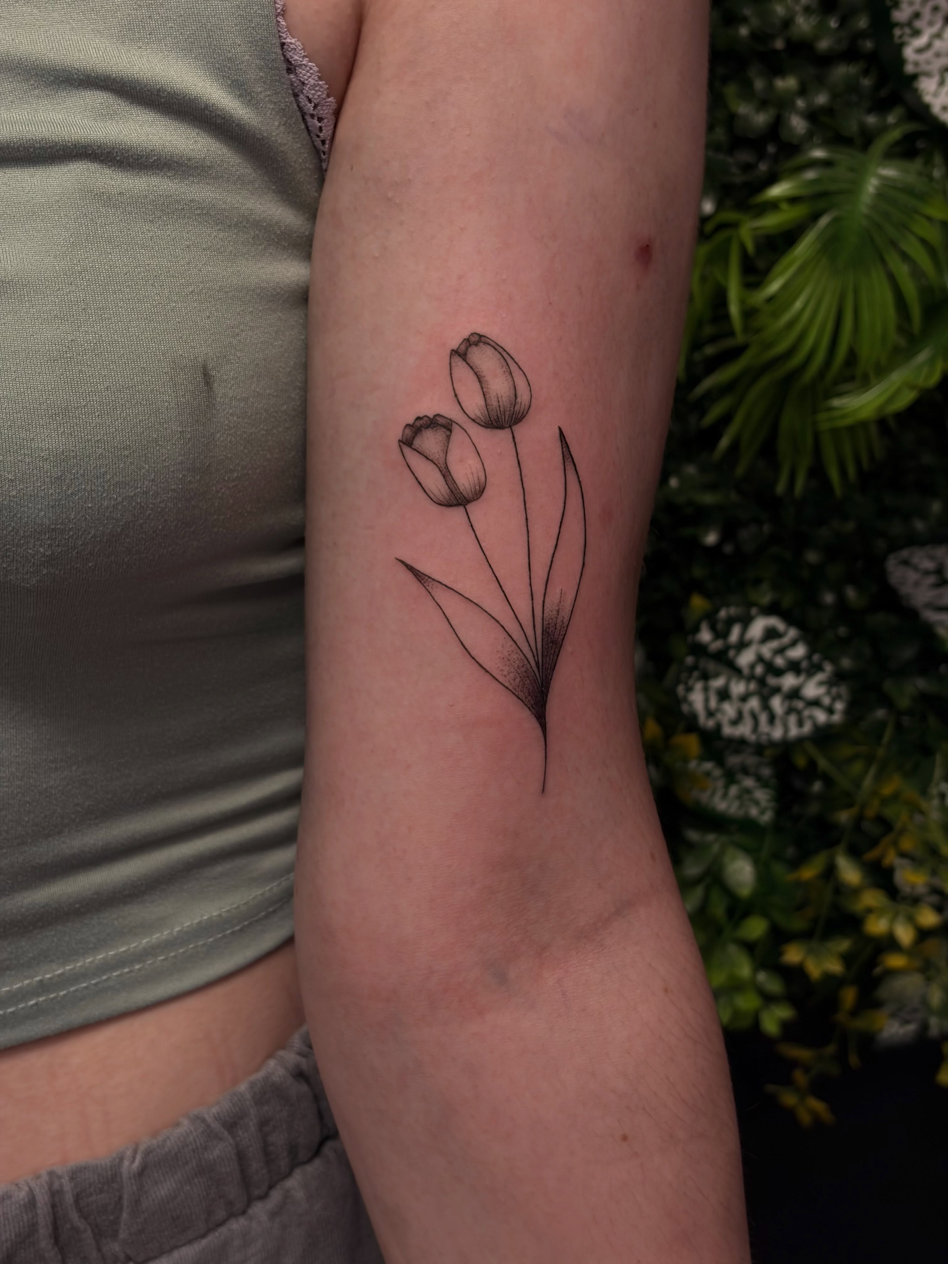Tulips fine line tattoo on the forearm by Melissa