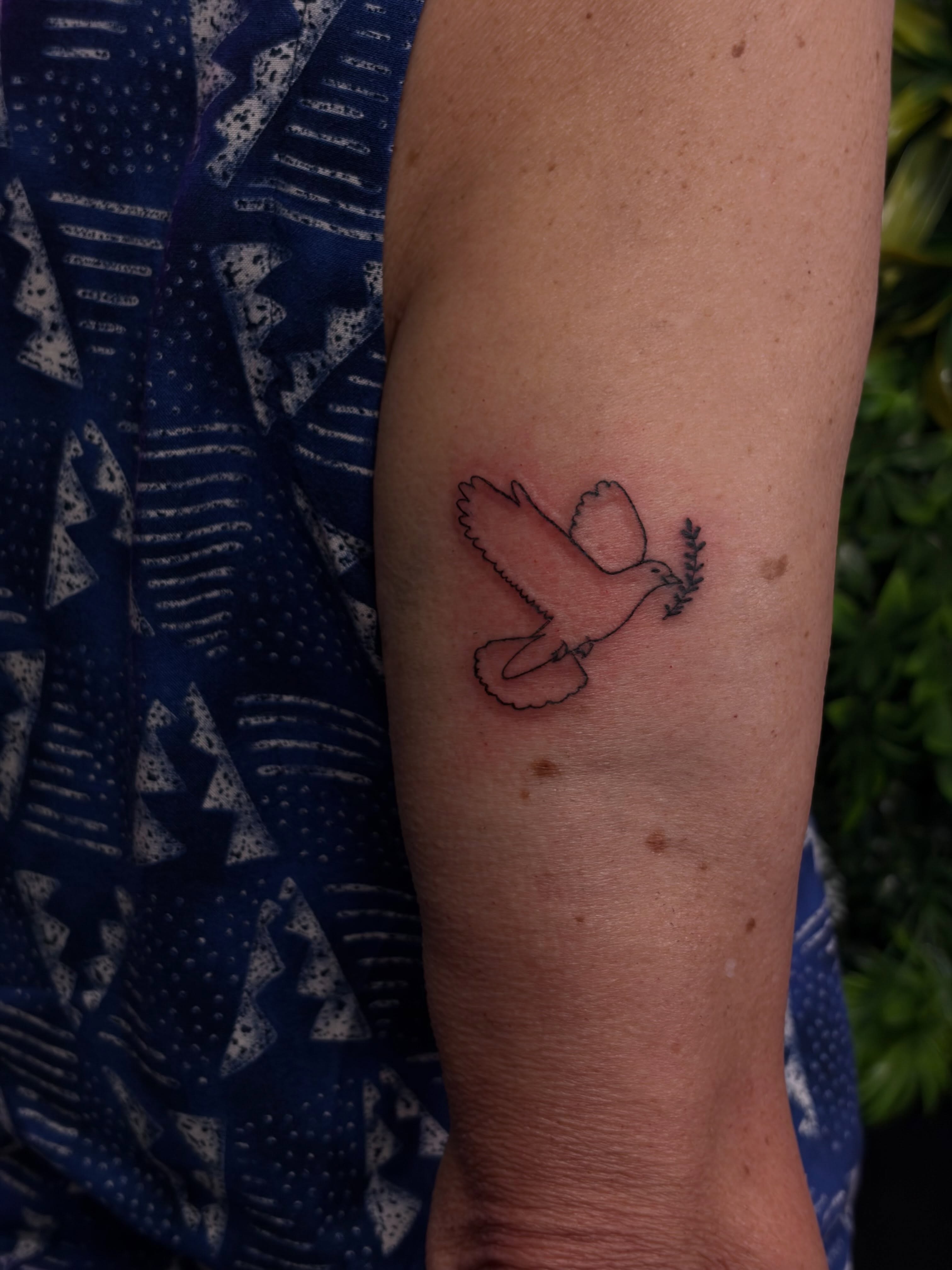 Peace dove fine line tattoo on the forearm by Melissa