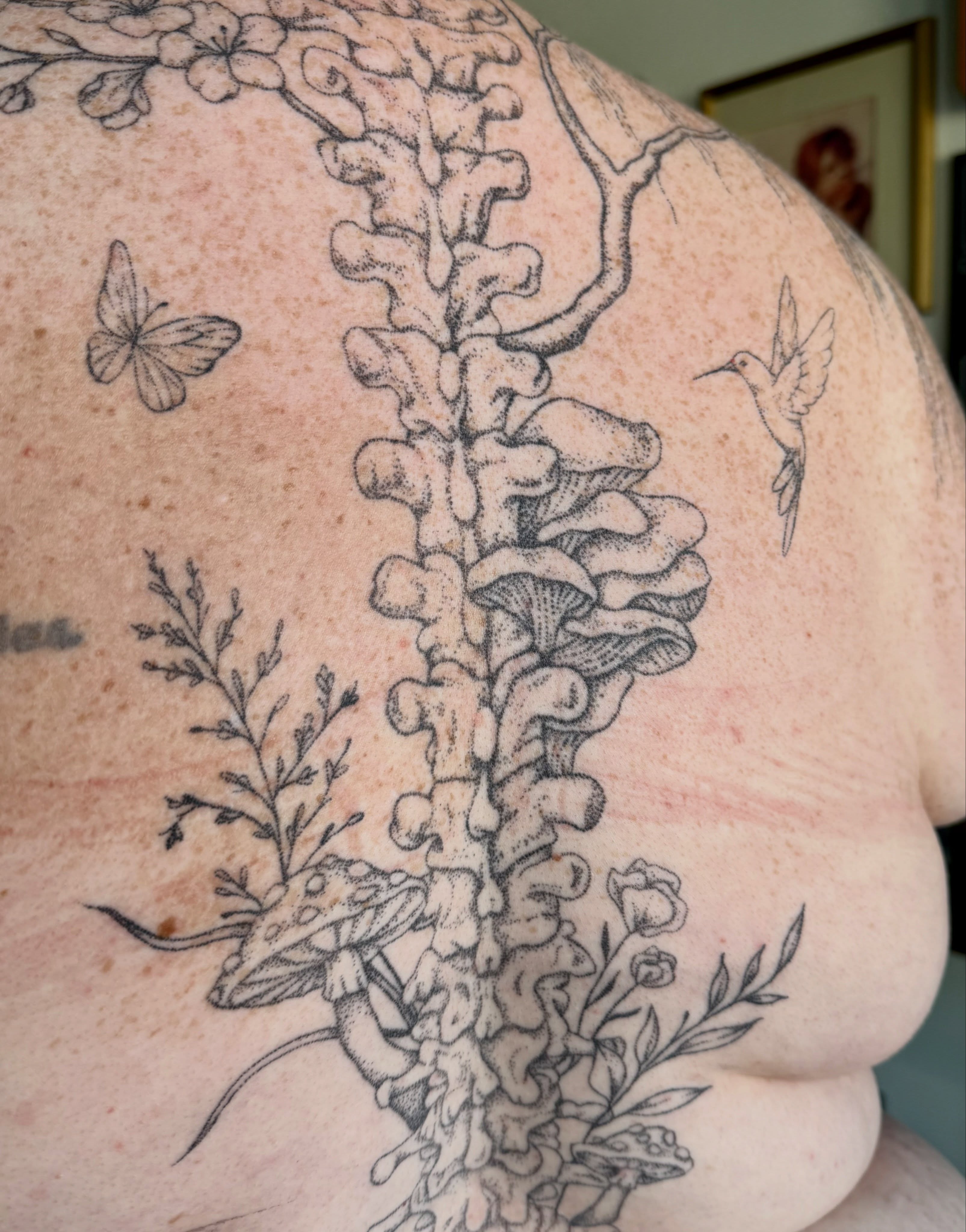 Spine with flora dotwork tattoo on the back by Ashley, Elk Horn, Iowa